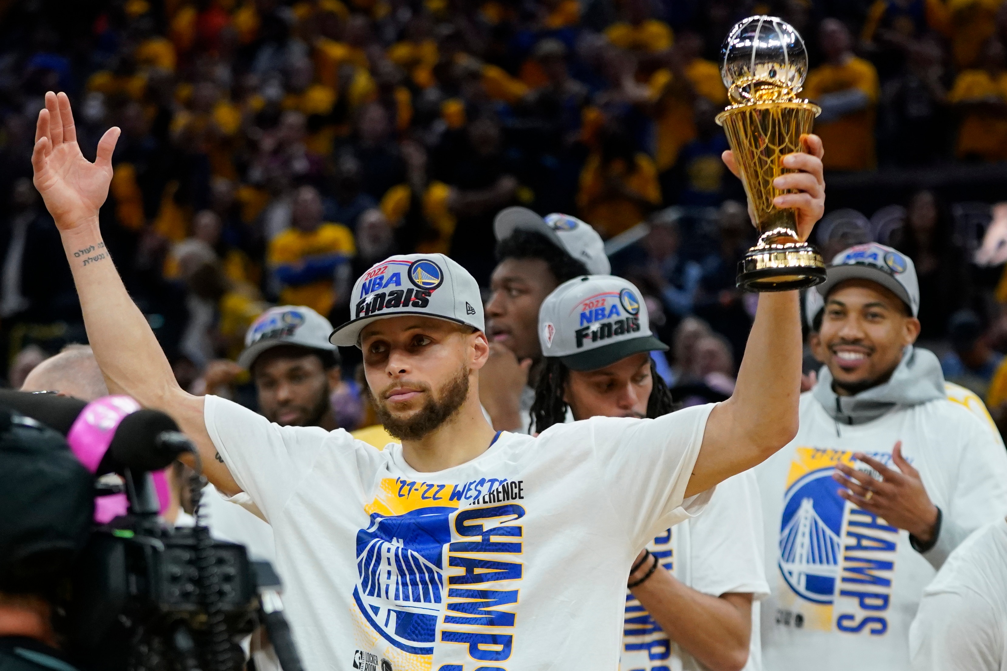 Golden State Warriors' Stephen Curry holds up the conference finals MVP trophy after the Warriors defeated the Dallas Mavericks in Game 5 of the NBA basketball playoffs Western Conference finals in San Francisco, Thursday, May 26, 2022. (AP Photo/Jeff Chiu)