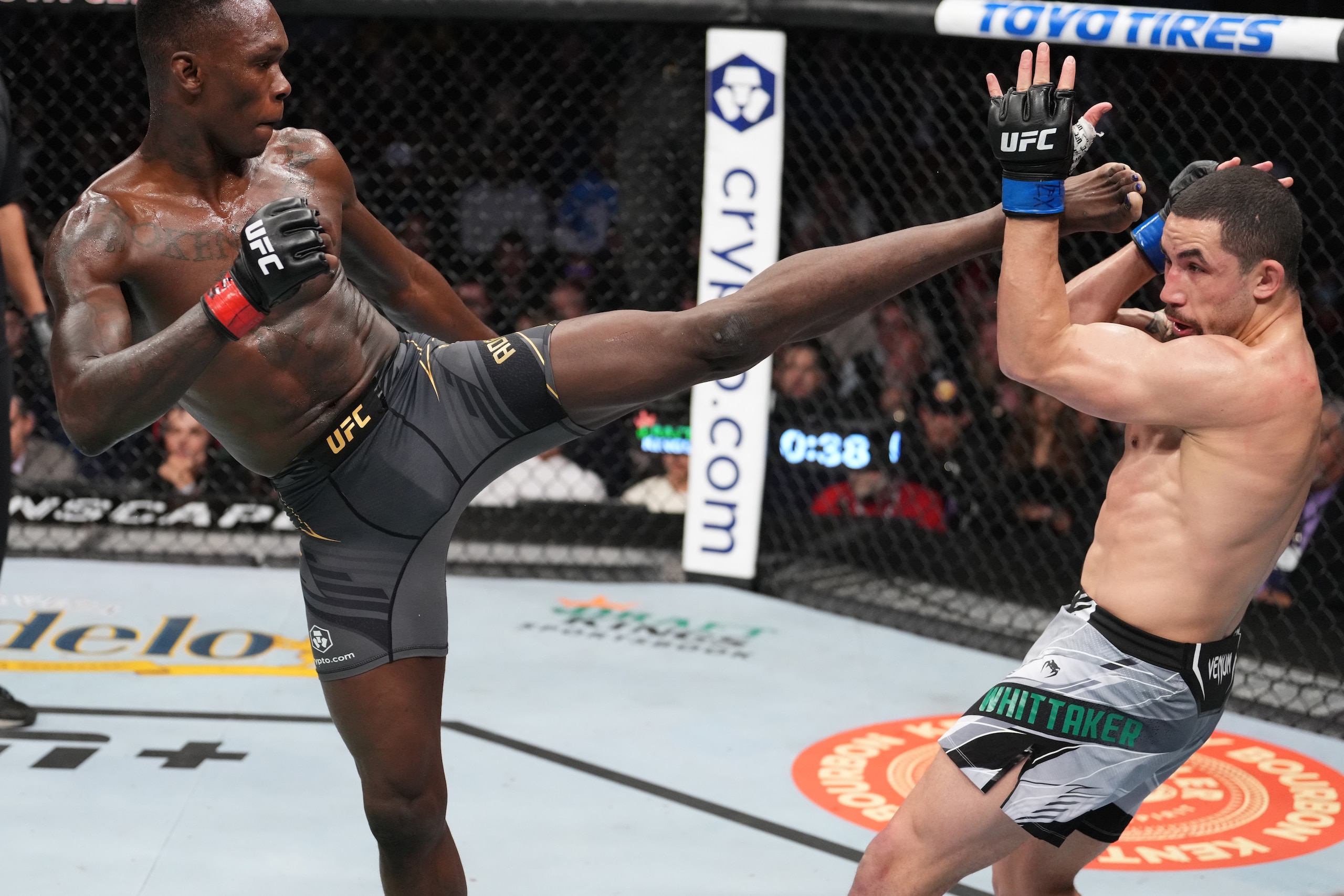 HOUSTON, TEXAS - FEBRUARY 12: (L-R) Israel Adesanya of Nigeria kicks Robert Whittaker of Australia in their UFC middleweight championship fight during the UFC 271 event at Toyota Center on February 12, 2022 in Houston, Texas. (Photo by Josh Hedges/Zuffa LLC)