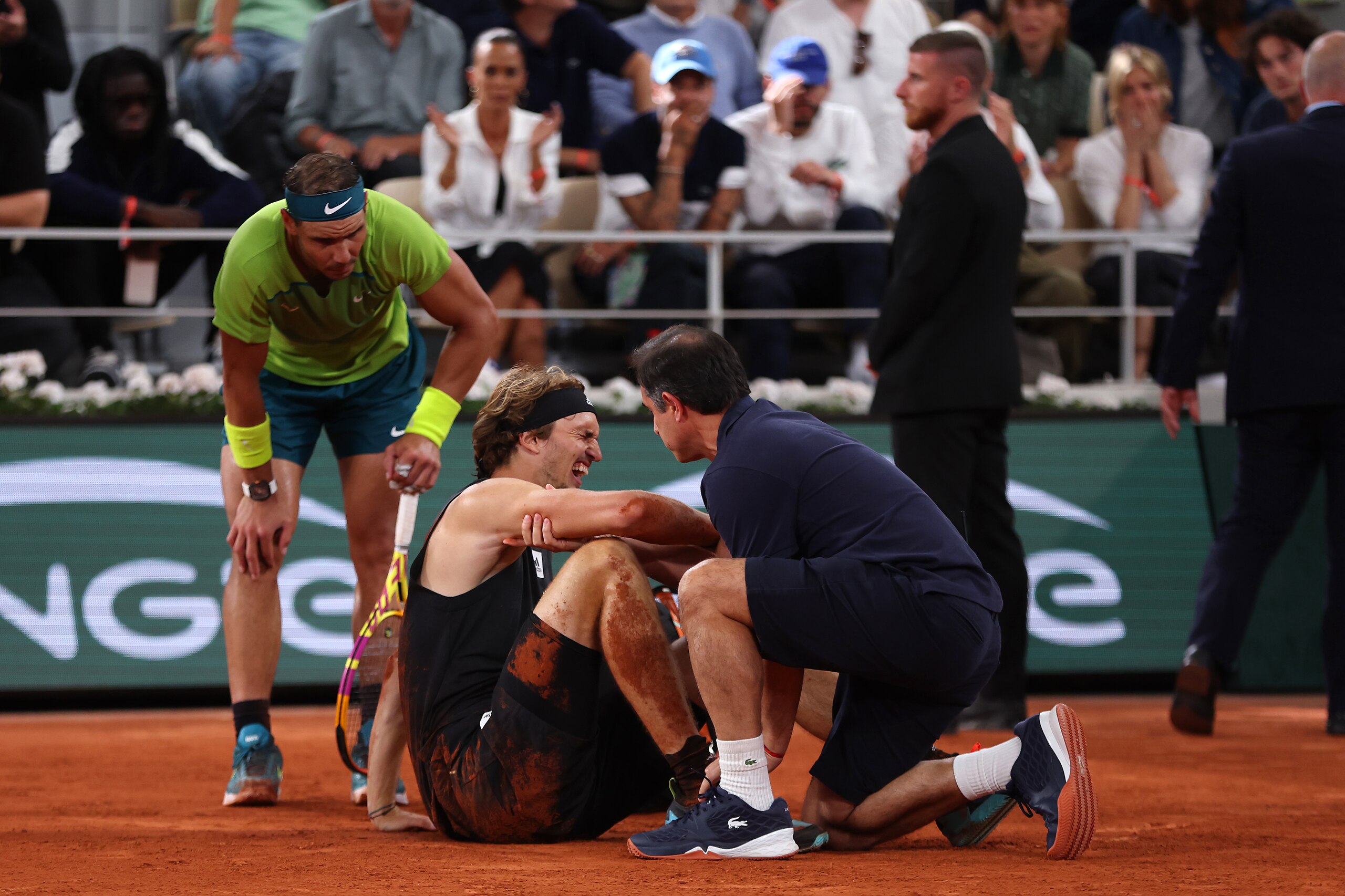 PARIS, FRANCE - JUNE 03: Alexander Zverev of Germany receives medical attention following an injury against Rafael Nadal of Spain during the Men's Singles Semi Final match on Day 13 of The 2022 French Open at Roland Garros on June 03, 2022 in Paris, France. (Photo by Clive Brunskill/Getty Images)