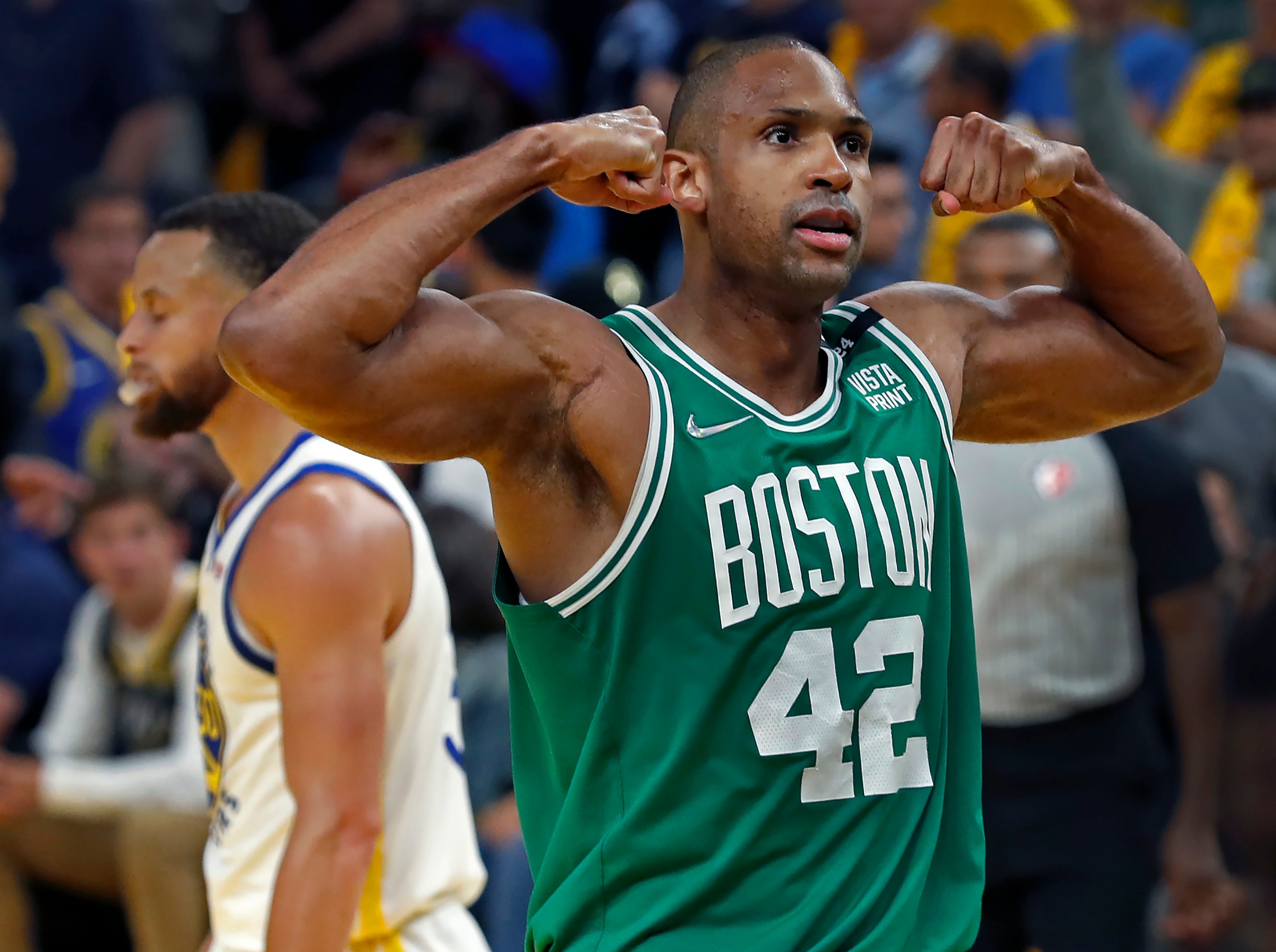 Boston - June 2: The Celtics Al Horford flexes to the crowd after Boston scored a late fourth quarter basket as they pulled away from Golden State for the victory. The Warriors Stephen Curry (30) looks dejected at left behind Horford. The Boston Celtics visited the Golden State Warriors for Game One of the NBA Finals at the Chase Center in San Francisco, CA on June 2, 2022. (Photo by Jim Davis/The Boston Globe via Getty Images)