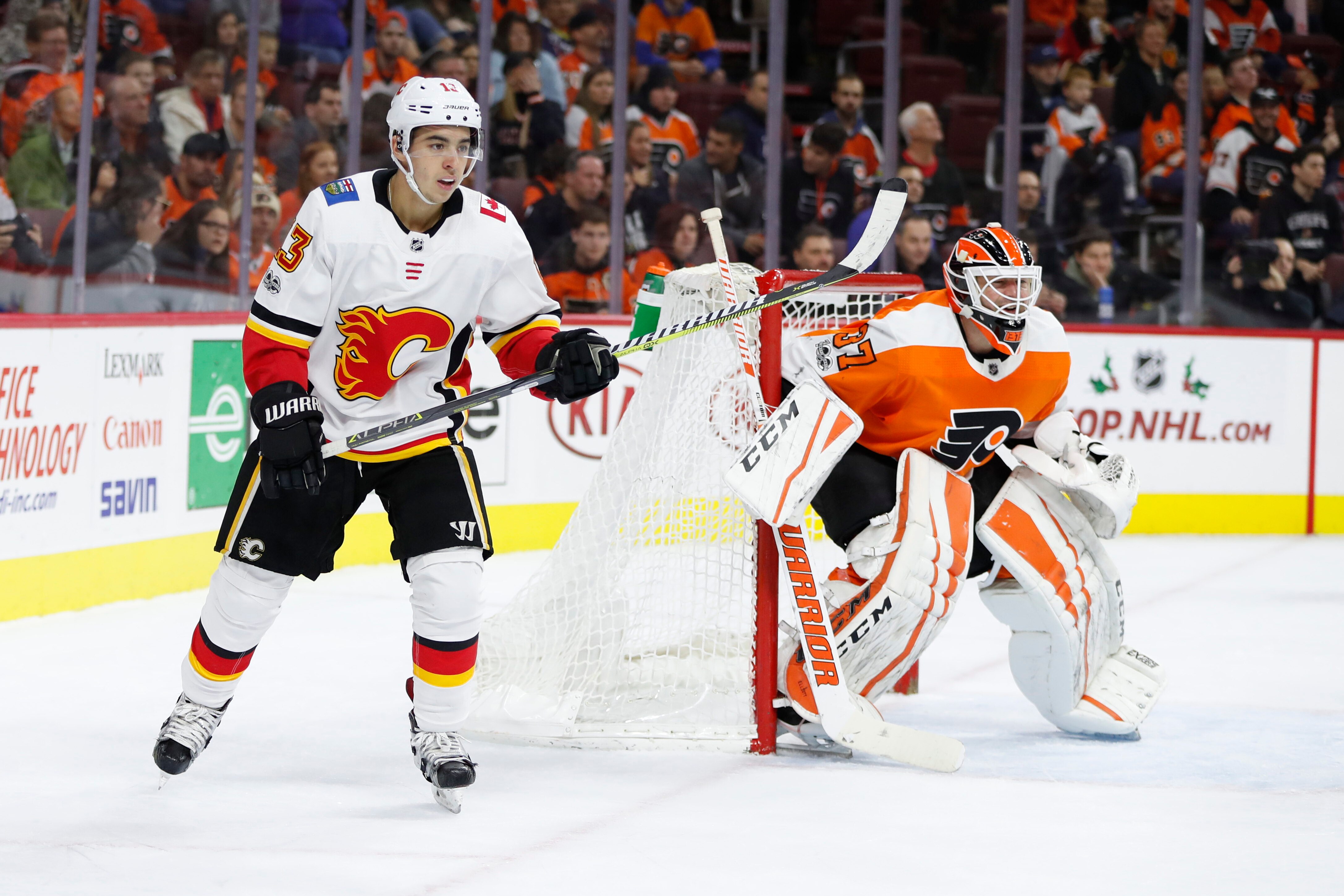 Calgary Flames' Johnny Gaudreau, left, looks on besides Philadelphia Flyers' Brian Elliott, right, during the first period of an NHL hockey game, Saturday, Nov. 18, 2017, in Philadelphia. The Flames won 5-4 in overtime. (AP Photo/Chris Szagola)