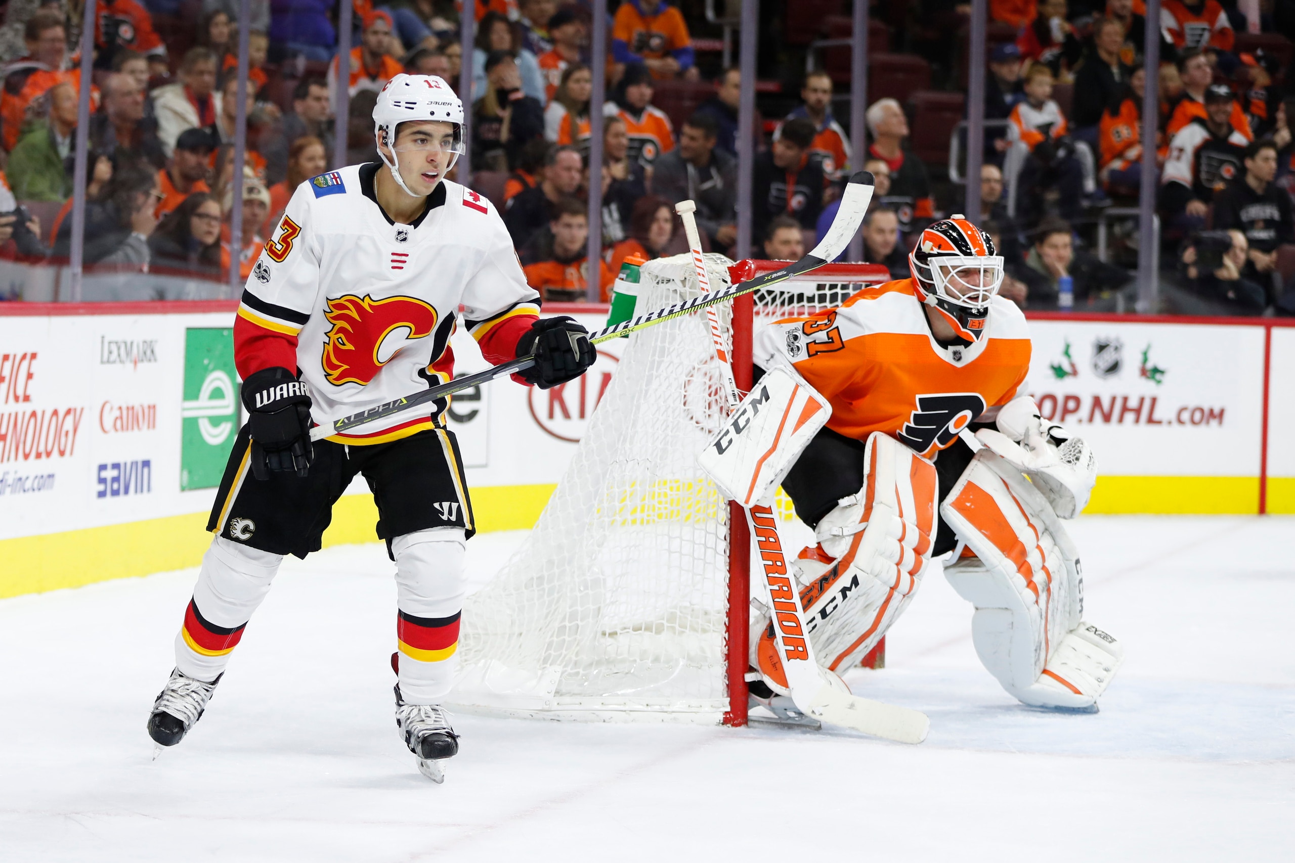 Calgary Flames' Johnny Gaudreau, left, looks on besides Philadelphia Flyers' Brian Elliott, right, during the first period of an NHL hockey game, Saturday, Nov. 18, 2017, in Philadelphia. The Flames won 5-4 in overtime. (AP Photo/Chris Szagola)