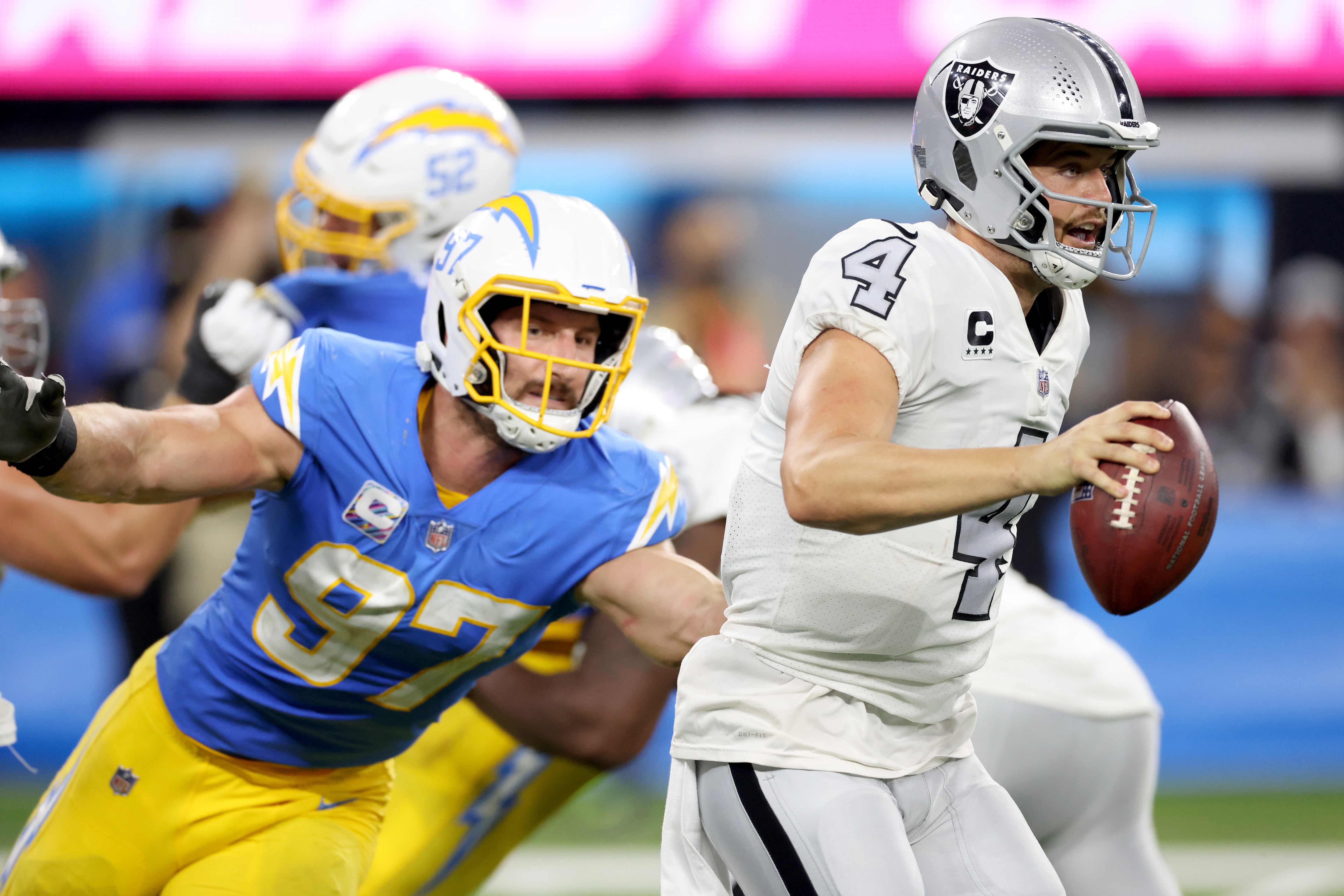 INGLEWOOD, CALIFORNIA - OCTOBER 04: Derek Carr #4 of the Las Vegas Raiders scrambles away from Joey Bosa #97 of the Los Angeles Chargers during a 28-14 loss to the Chargers at SoFi Stadium on October 04, 2021 in Inglewood, California. (Photo by Harry How/Getty Images)
