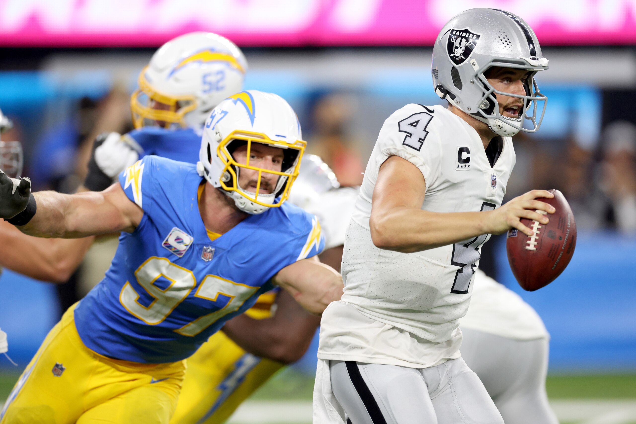 INGLEWOOD, CALIFORNIA - OCTOBER 04: Derek Carr #4 of the Las Vegas Raiders scrambles away from Joey Bosa #97 of the Los Angeles Chargers during a 28-14 loss to the Chargers at SoFi Stadium on October 04, 2021 in Inglewood, California. (Photo by Harry How/Getty Images)
