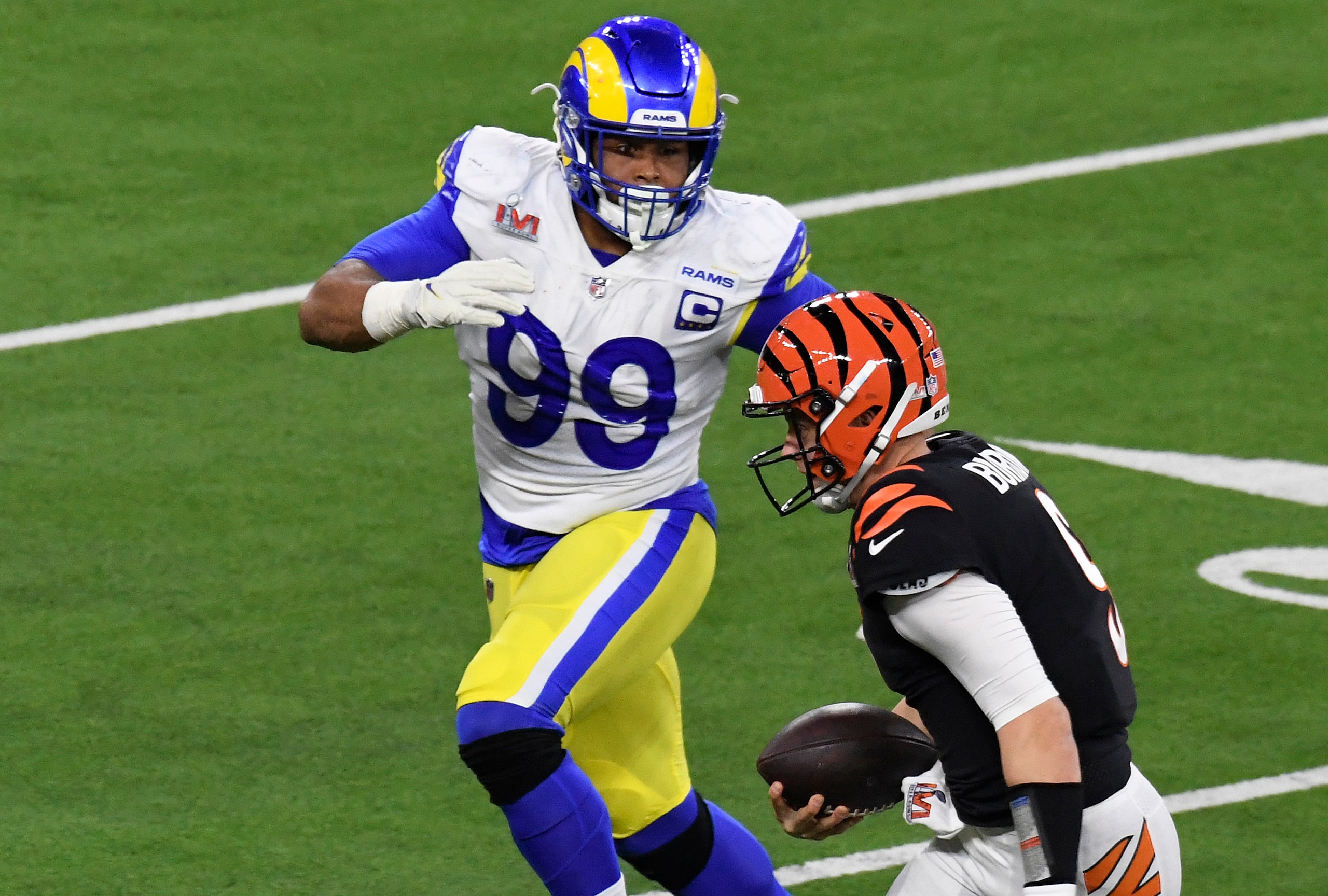 INGLEWOOD, CALIFORNIA - FEBRUARY 13: Joe Burrow #9 of the Cincinnati Bengals running with the ball is pursued by Aaron Donald #99 of the Los Angeles Rams during Super Bowl LVI at SoFi Stadium on February 13, 2022 in Inglewood, California. (Photo by Focus on Sport/Getty Images)