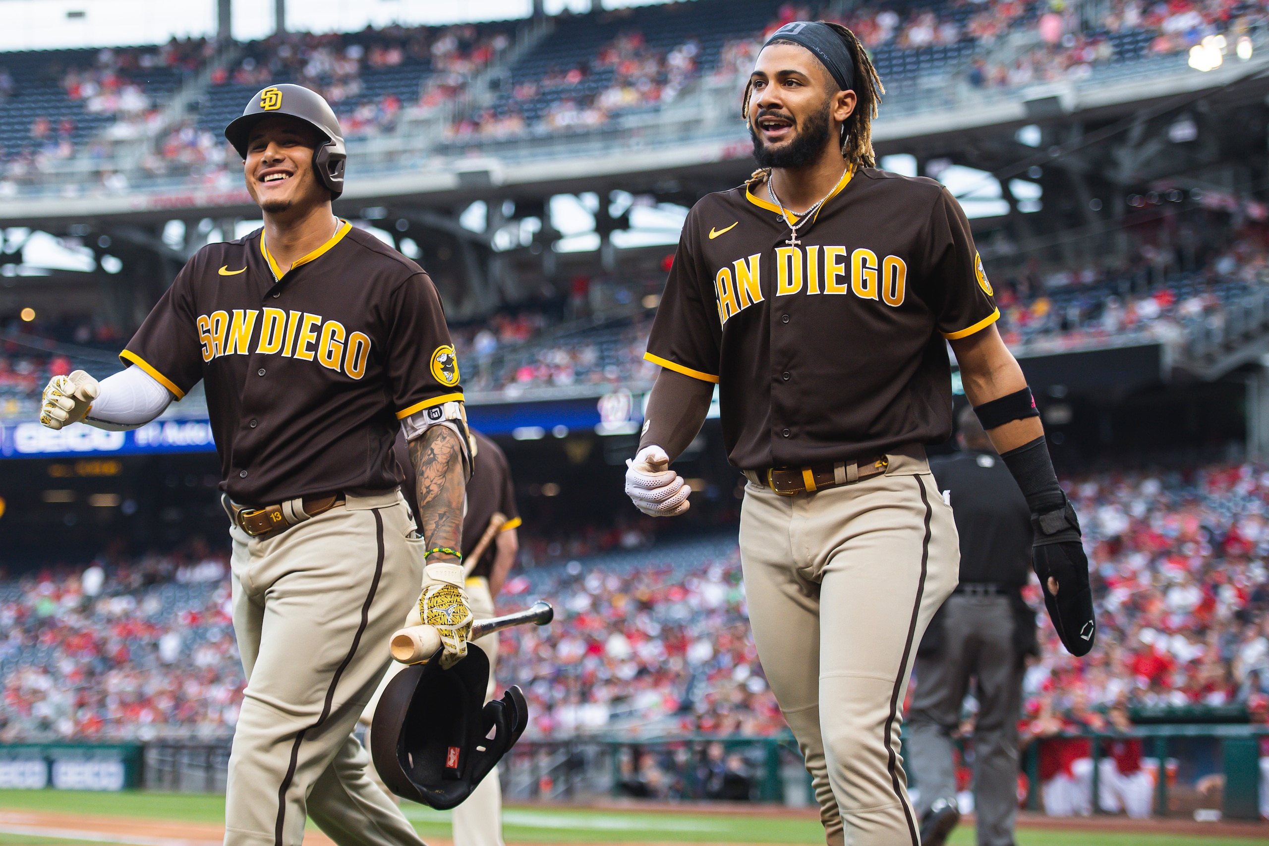 WASHINGTON, D.C. - JULY 17: Fernando Tatis Jr. #23 celebrates with Manny Machado #13 of the San Diego Padres after sliding into home plate and scoring in the first inning against the Washington Nationals at Nationals Park on July 17, 2021 in Washington, DC.  (Photo by Matt Thomas/San Diego Padres/Getty Images)