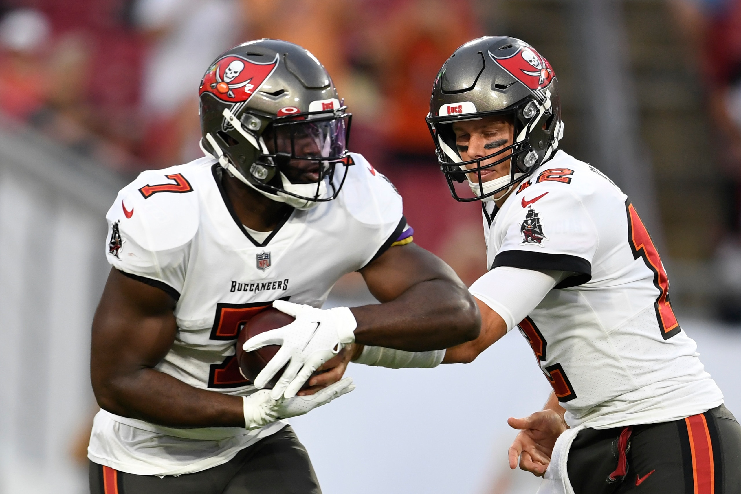 TAMPA, FLORIDA - AUGUST 14: Tom Brady #12 looks to hand the ball off to Leonard Fournette #7 of the Tampa Bay Buccaneers during the first quarter against the Cincinnati Bengals during a preseason game at Raymond James Stadium on August 14, 2021 in Tampa, Florida. (Photo by Douglas P. DeFelice/Getty Images)