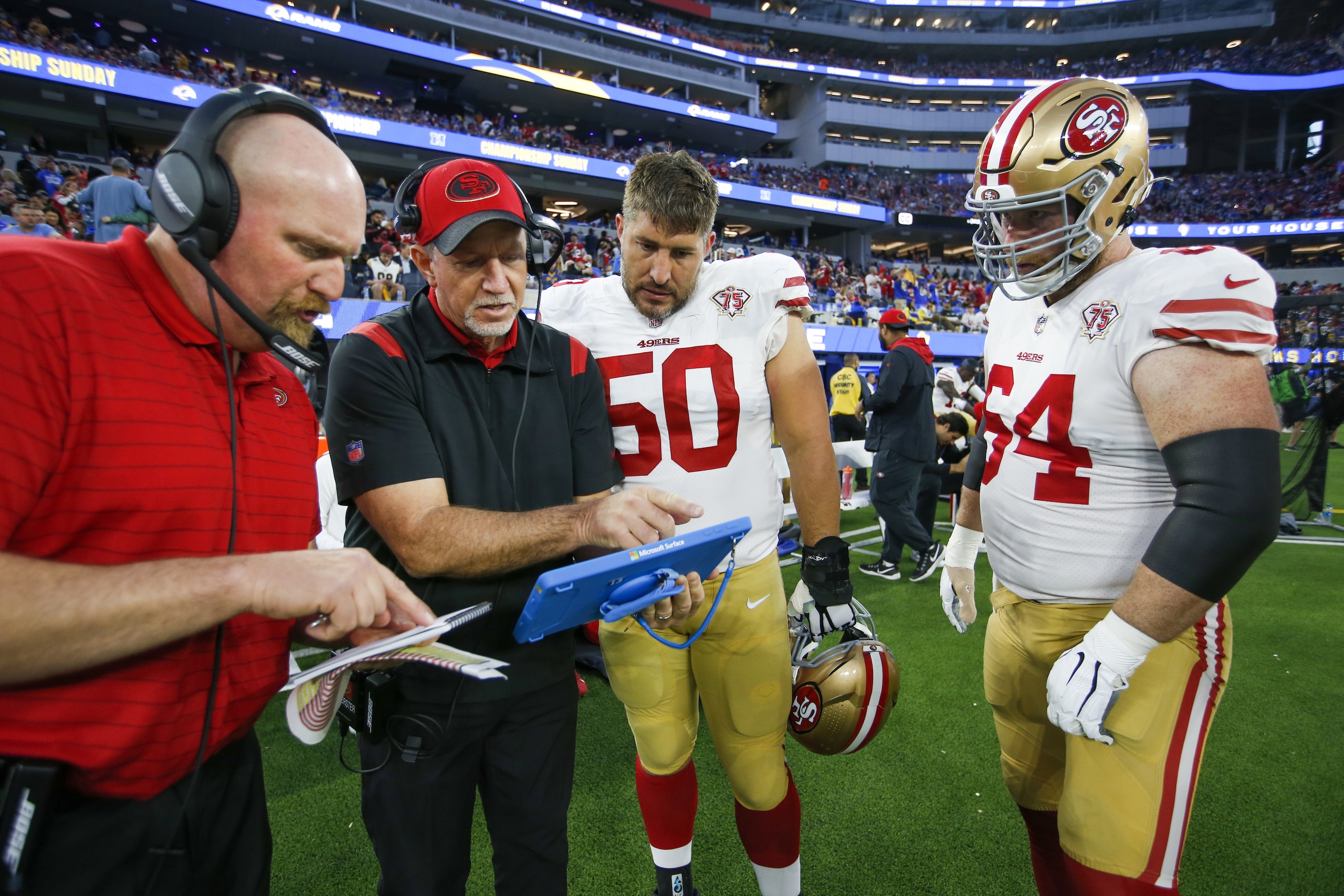 INGLEWOOD, CA - JANUARY 30: Offensive Line Coach Chris Foerster of the San Francisco 49ers talks with Alex Mack #50 and Jake Brendel #64 on the sidelines during the game against the Los Angeles Rams at SoFi Stadium on January 30, 2022 in Inglewood, California. The Rams defeated the 49ers 20-17. (Photo by Michael Zagaris/San Francisco 49ers/Getty Images)