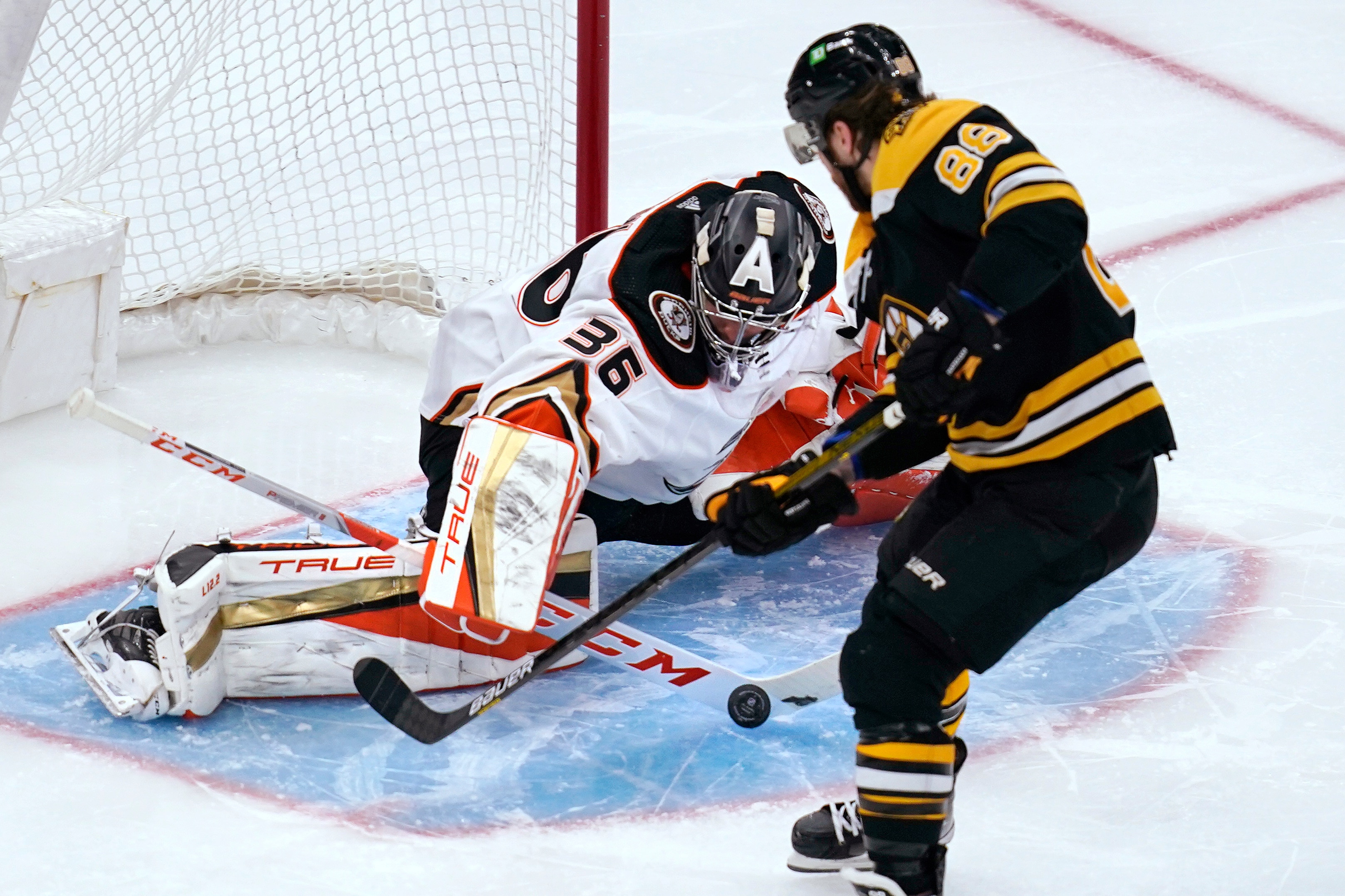Anaheim Ducks goaltender John Gibson (36) makes a stick-save on a shot by Boston Bruins right wing David Pastrnak (88) during the second period of an NHL hockey game, Monday, Jan. 24, 2022, in Boston. (AP Photo/Charles Krupa)
