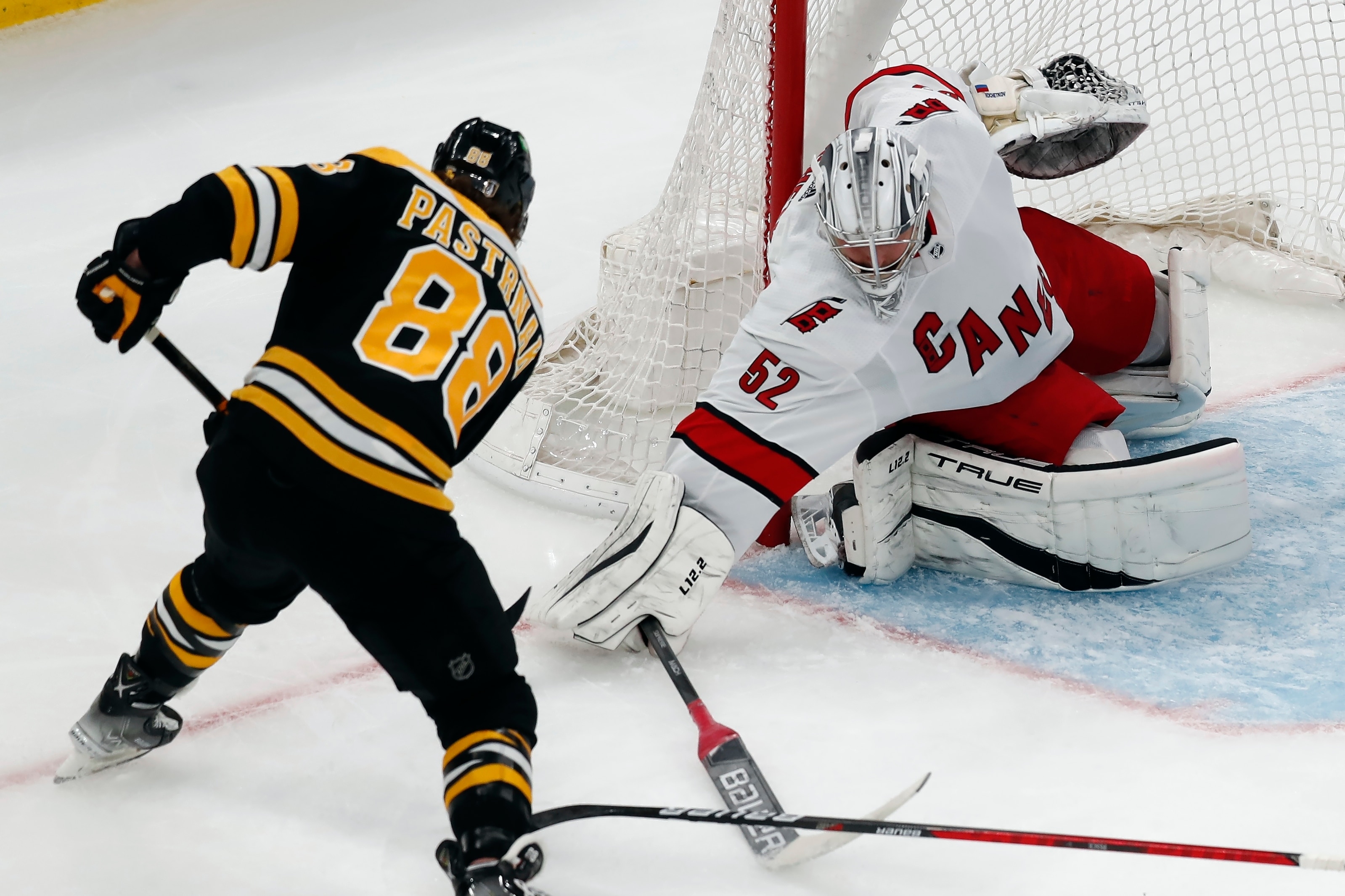 Carolina Hurricanes' Pyotr Kochetkov (52) blocks a shot by Boston Bruins' David Pastrnak (88) during the second period of Game 3 of an NHL hockey Stanley Cup first-round playoff series, Friday, May 6, 2022, in Boston. (AP Photo/Michael Dwyer)