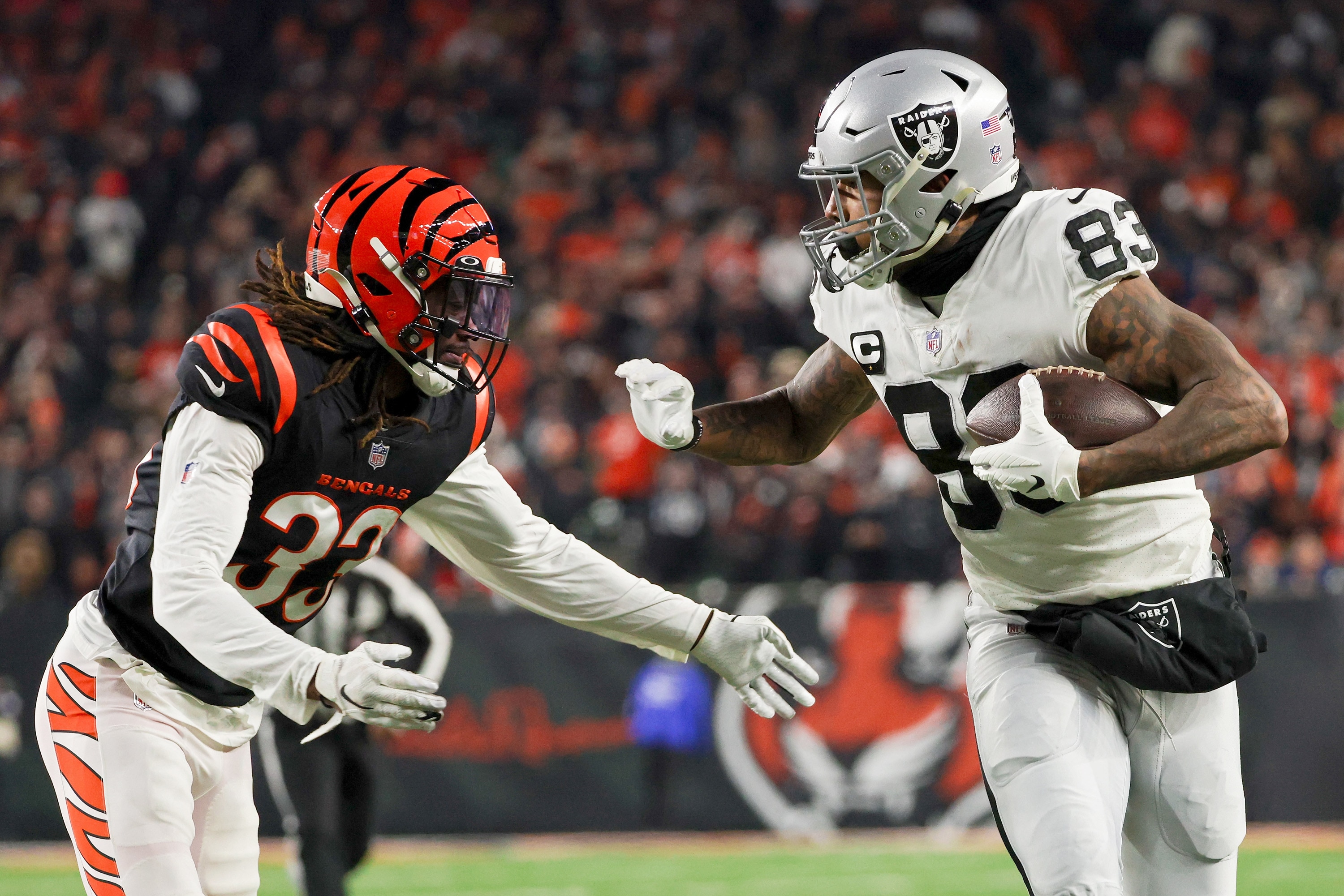 CINCINNATI, OHIO - JANUARY 15: Darren Waller #83 of the Las Vegas Raiders runs with the ball while being chased by Tre Flowers #33 of the Cincinnati Bengals in the second quarter during the AFC Wild Card playoff game at Paul Brown Stadium on January 15, 2022 in Cincinnati, Ohio. (Photo by Dylan Buell/Getty Images)