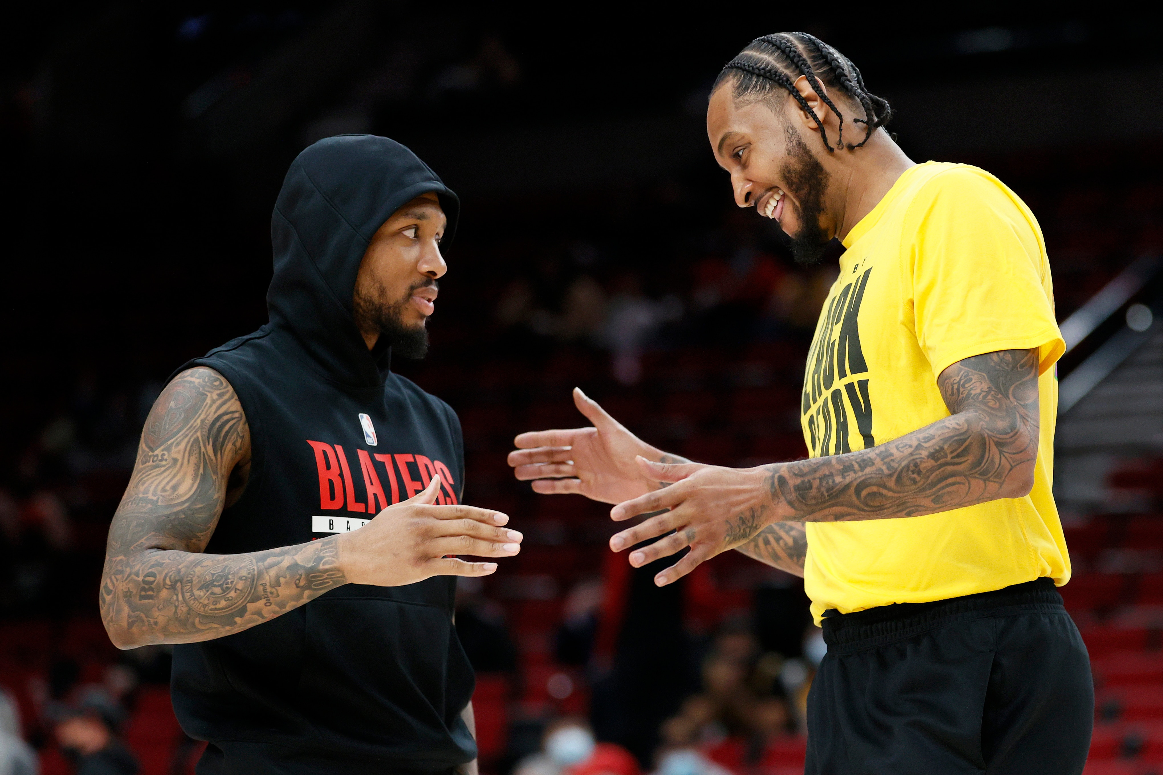 PORTLAND, OREGON - FEBRUARY 09:  Damian Lillard #0 of the Portland Trail Blazers greets Carmelo Anthony #7 of the Los Angeles Lakers before the game at Moda Center on February 09, 2022 in Portland, Oregon. NOTE TO USER: User expressly acknowledges and agrees that, by downloading and/or using this photograph, User is consenting to the terms and conditions of the Getty Images License Agreement. (Photo by Steph Chambers/Getty Images)
