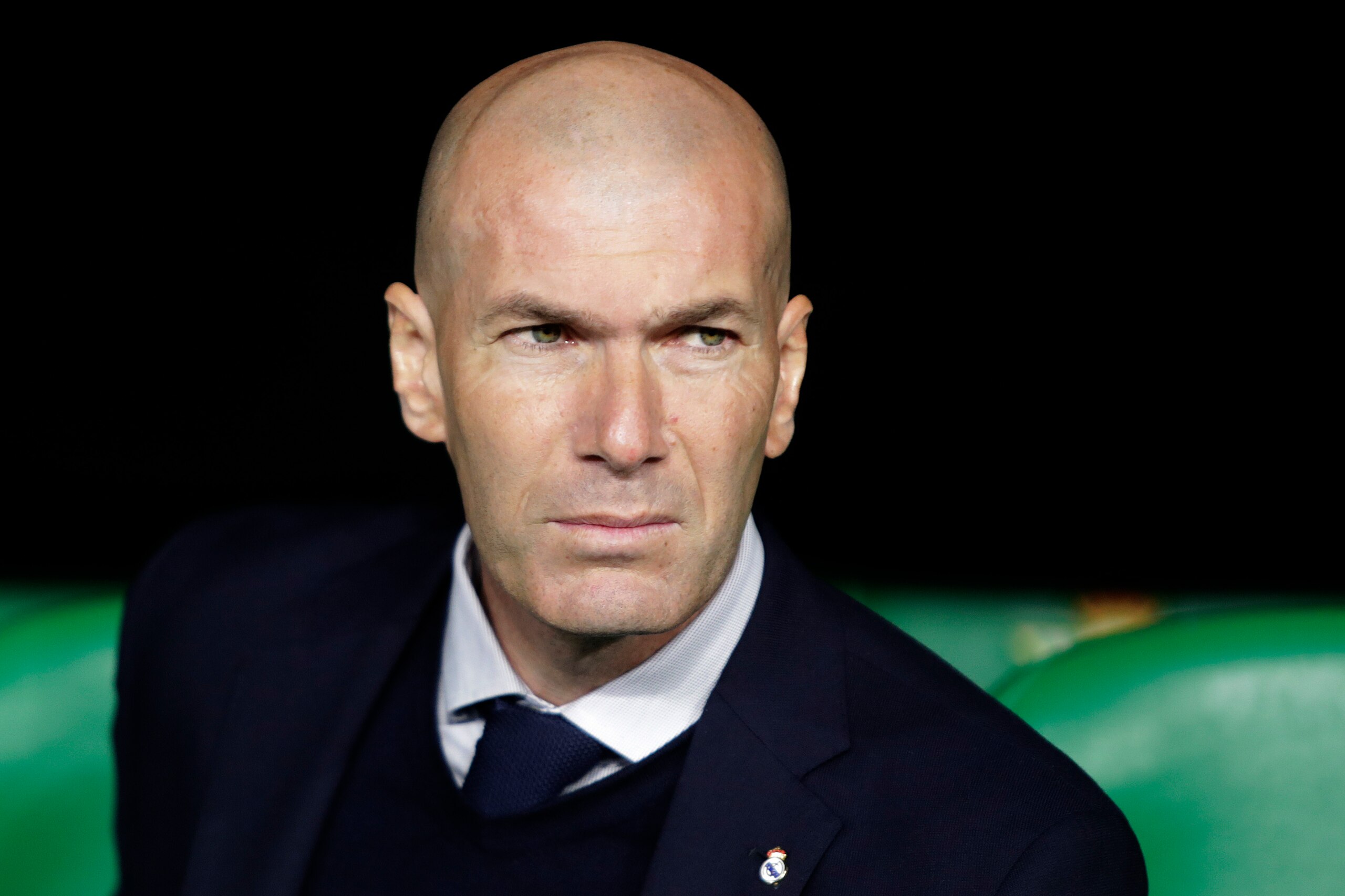 FILE - In this In this file photo dated March 8, 2020, Real Madrid's head coach Zinedine Zidane sits at the bench during La Liga soccer match in Seville, Spain. Zinedine Zidane is again stepping down as Real Madrid coach. The club says the Frenchman is leaving his job. It comes four days after a season in which Madrid failed to win a title for the first time in more than a decade. (AP Photo/Miguel Morenatti, File)