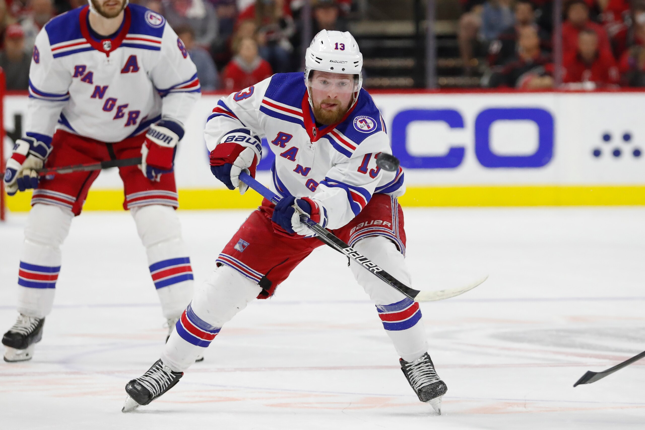 New York Rangers' Alexis Lafrenière (13) clears the puck against the Carolina Hurricanes during the first period of Game 5 of an NHL hockey Stanley Cup second-round playoff series in Raleigh, N.C., Thursday, May 26, 2022. (AP Photo/Karl B DeBlaker)