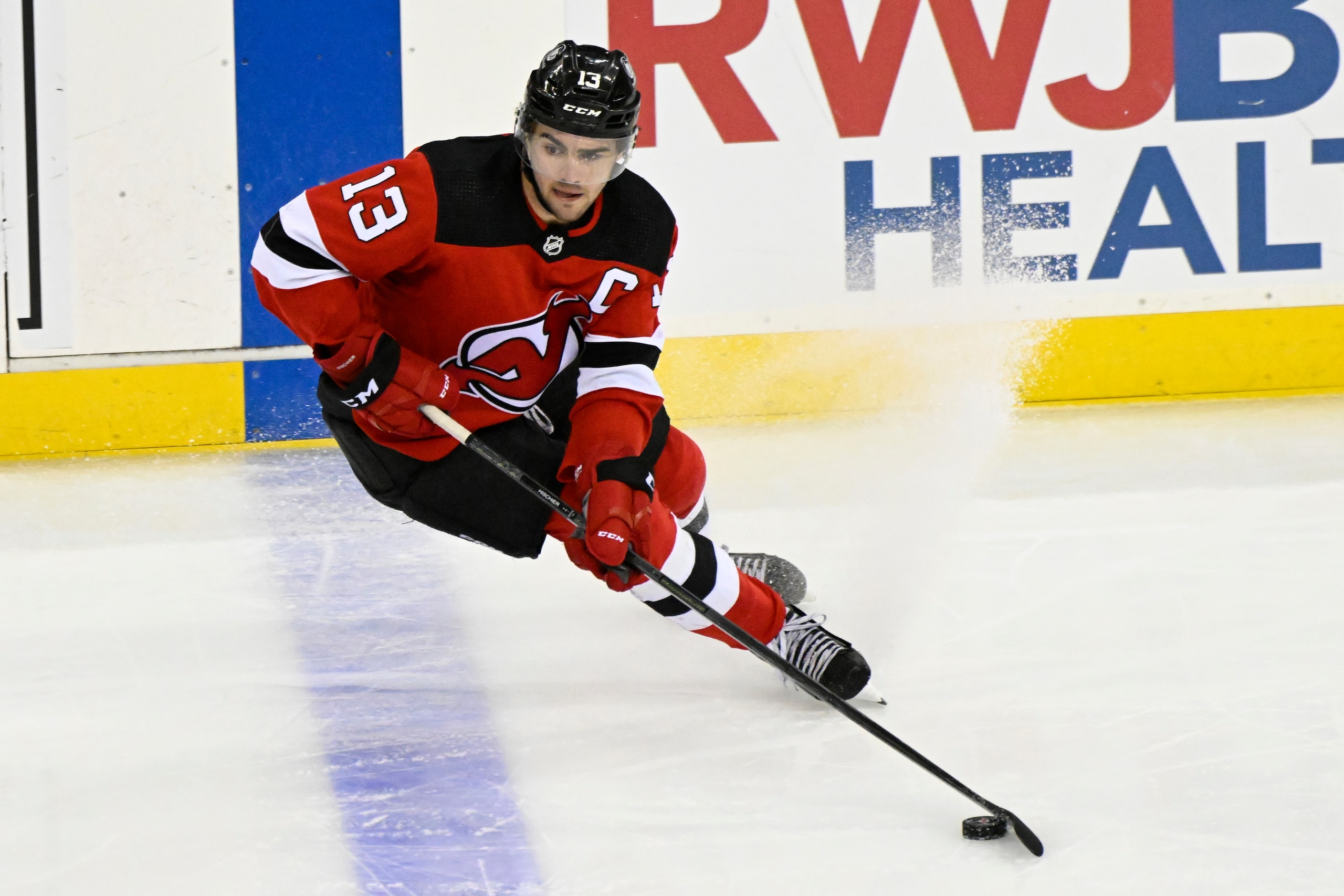 New Jersey Devils center Nico Hischier skates with the puck during the third period of an NHL hockey game against the Carolina Hurricanes Saturday, April 23, 2022, in Newark, N.J. (AP Photo/Bill Kostroun)