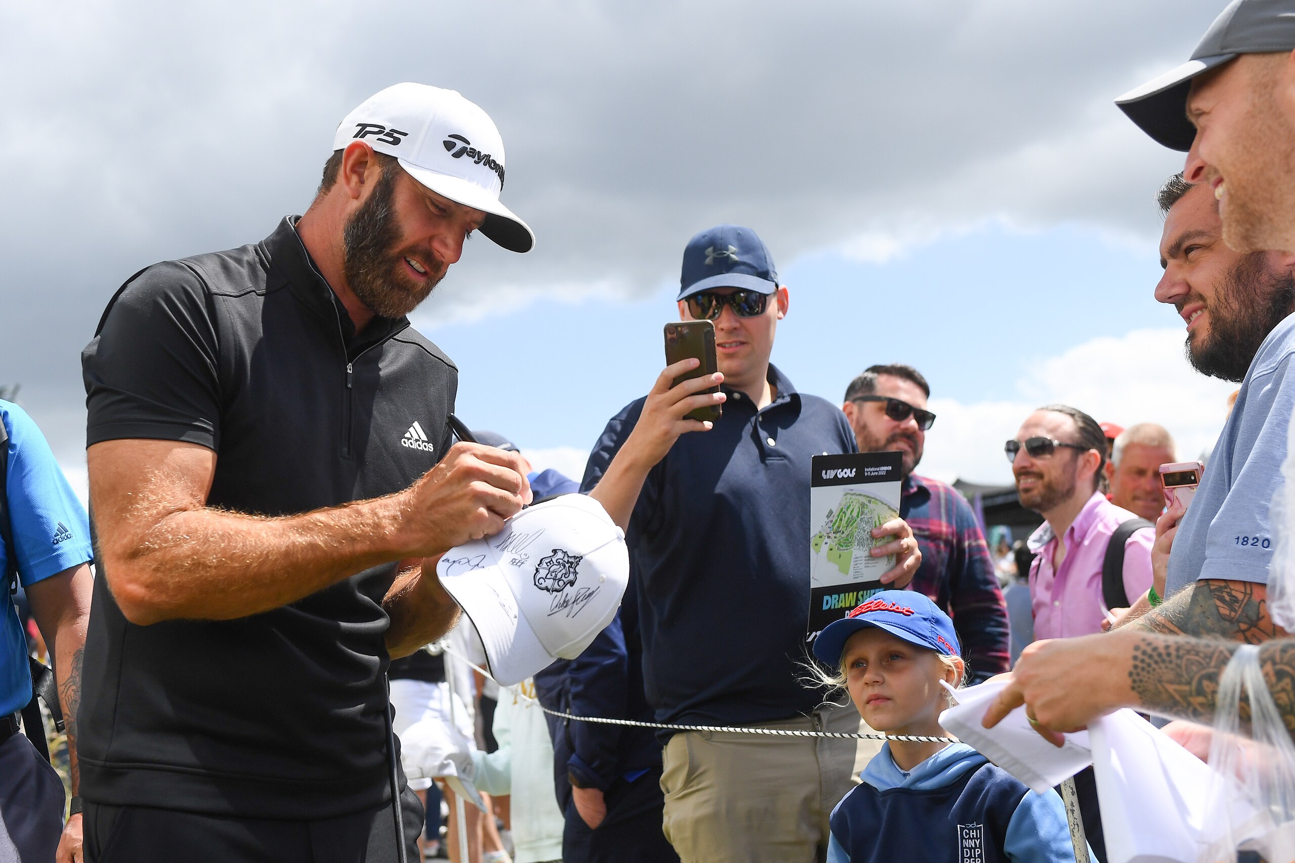 ST ALBANS, ENGLAND - JUNE 11: Dustin Johnson of 4 Aces GC signs autographs for fans during day three of LIV Golf Invitational - London at The Centurion Club on June 11, 2022 in St Albans, England. (Photo by Joe Maher/LIV Golf/Getty Images)