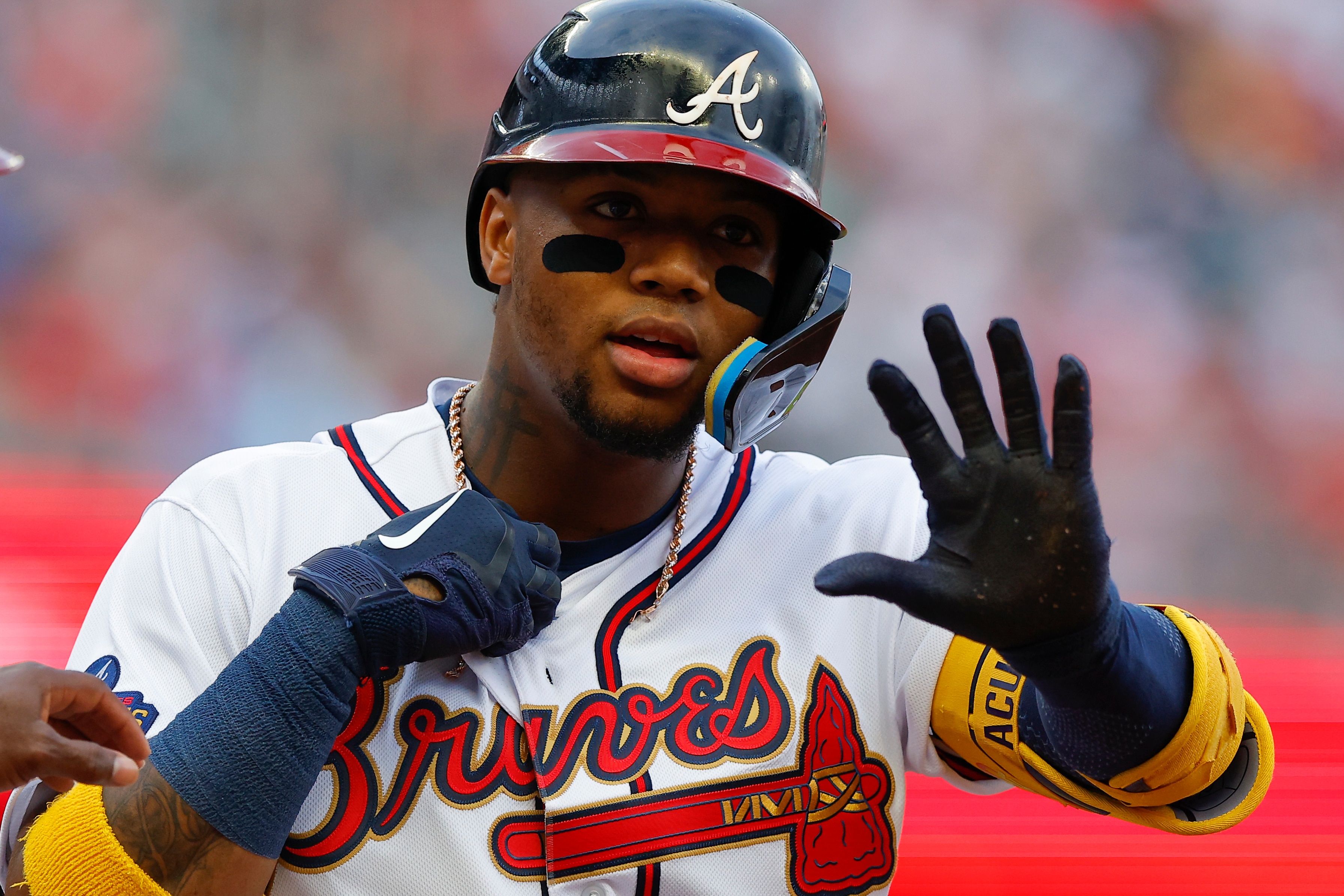 ATLANTA, GA - JUNE 08: Ronald Acuna Jr. #13 of the Atlanta Braves reacts as his necklace is broken after a hit during the first inning against the Oakland Athletics at Truist Park on June 8, 2022 in Atlanta, Georgia. (Photo by Todd Kirkland/Getty Images)