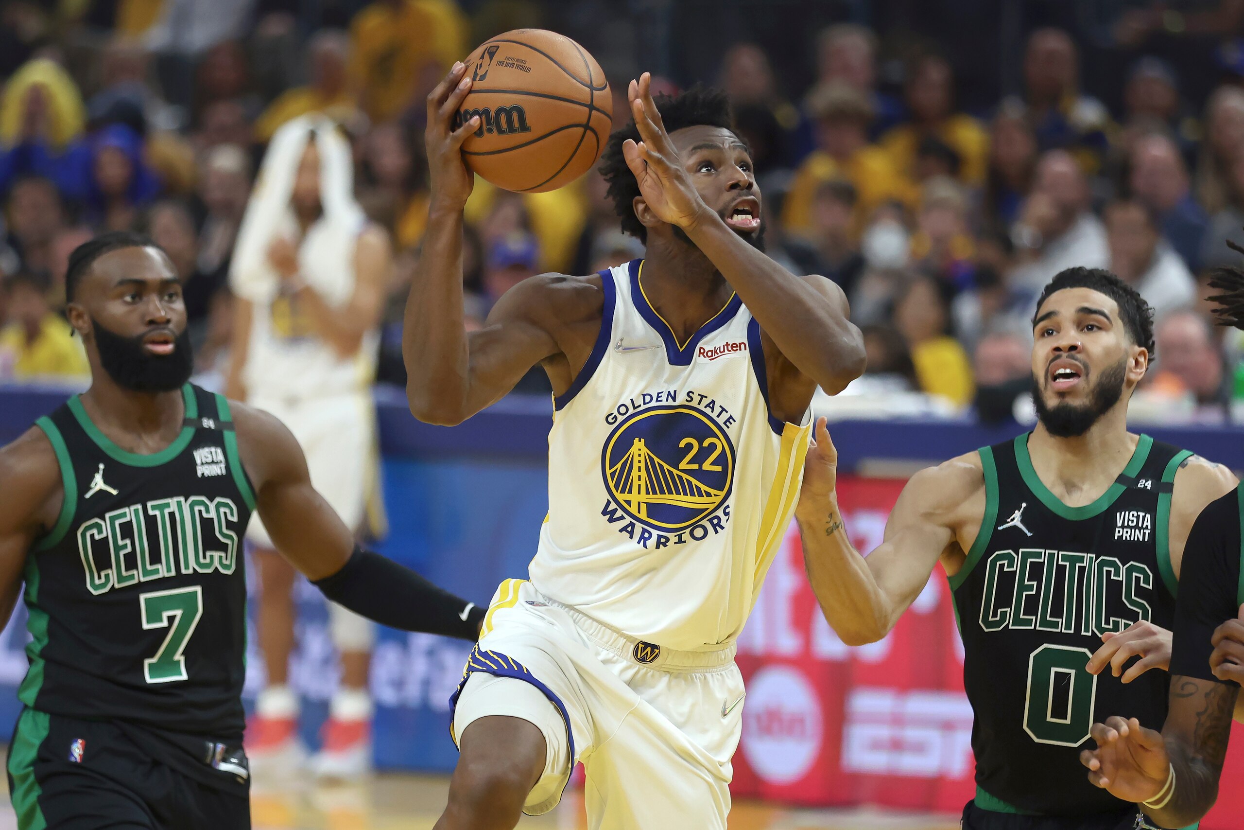 Golden State Warriors forward Andrew Wiggins (22) shoots against Boston Celtics guard Jaylen Brown (7) and forward Jayson Tatum (0) during the first half of Game 5 of basketball's NBA Finals in San Francisco, Monday, June 13, 2022. (AP Photo/Jed Jacobsohn)