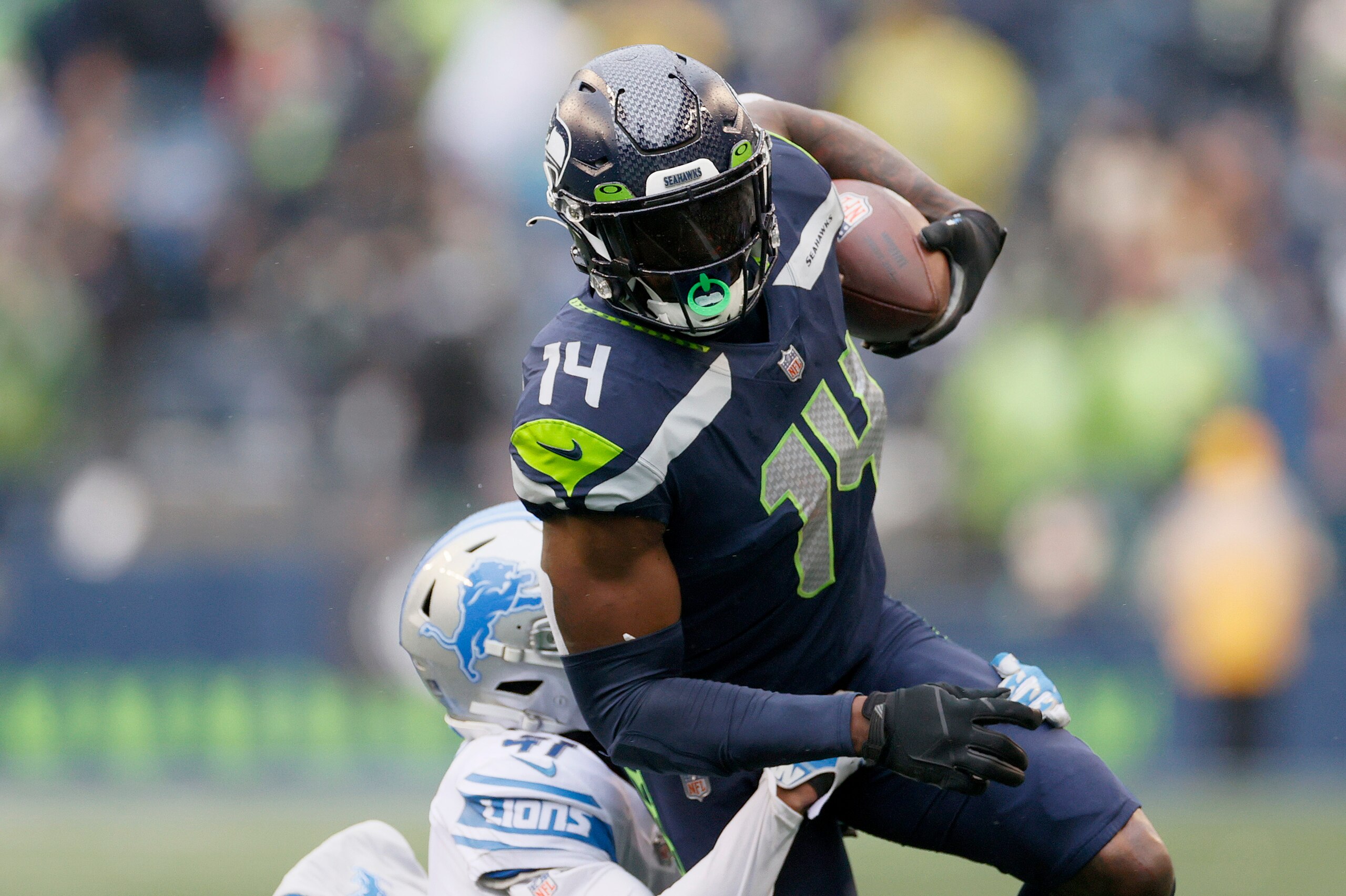 SEATTLE, WASHINGTON - JANUARY 02: DK Metcalf #14 of the Seattle Seahawks carries the ball against the Detroit Lions during the first half at Lumen Field on January 02, 2022 in Seattle, Washington. (Photo by Steph Chambers/Getty Images) SEATTLE, WASHINGTON - JANUARY 02: DK Metcalf #14 of the Seattle Seahawks carries the ball against the Detroit Lions during the first half at Lumen Field on January 02, 2022 in Seattle, Washington. (Photo by Steph Chambers/Getty Images)