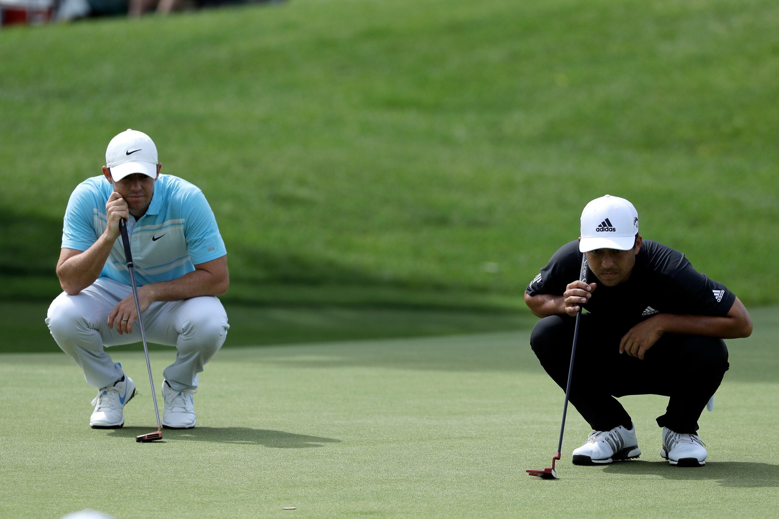 Rory McIlroy, of Northern Ireland, left, and Xander Schauffele line their shots on the fourth green during the third round of the Travelers Championship golf tournament at TPC River Highlands, Saturday, June 27, 2020, in Cromwell, Conn. (AP Photo/Frank Franklin II)