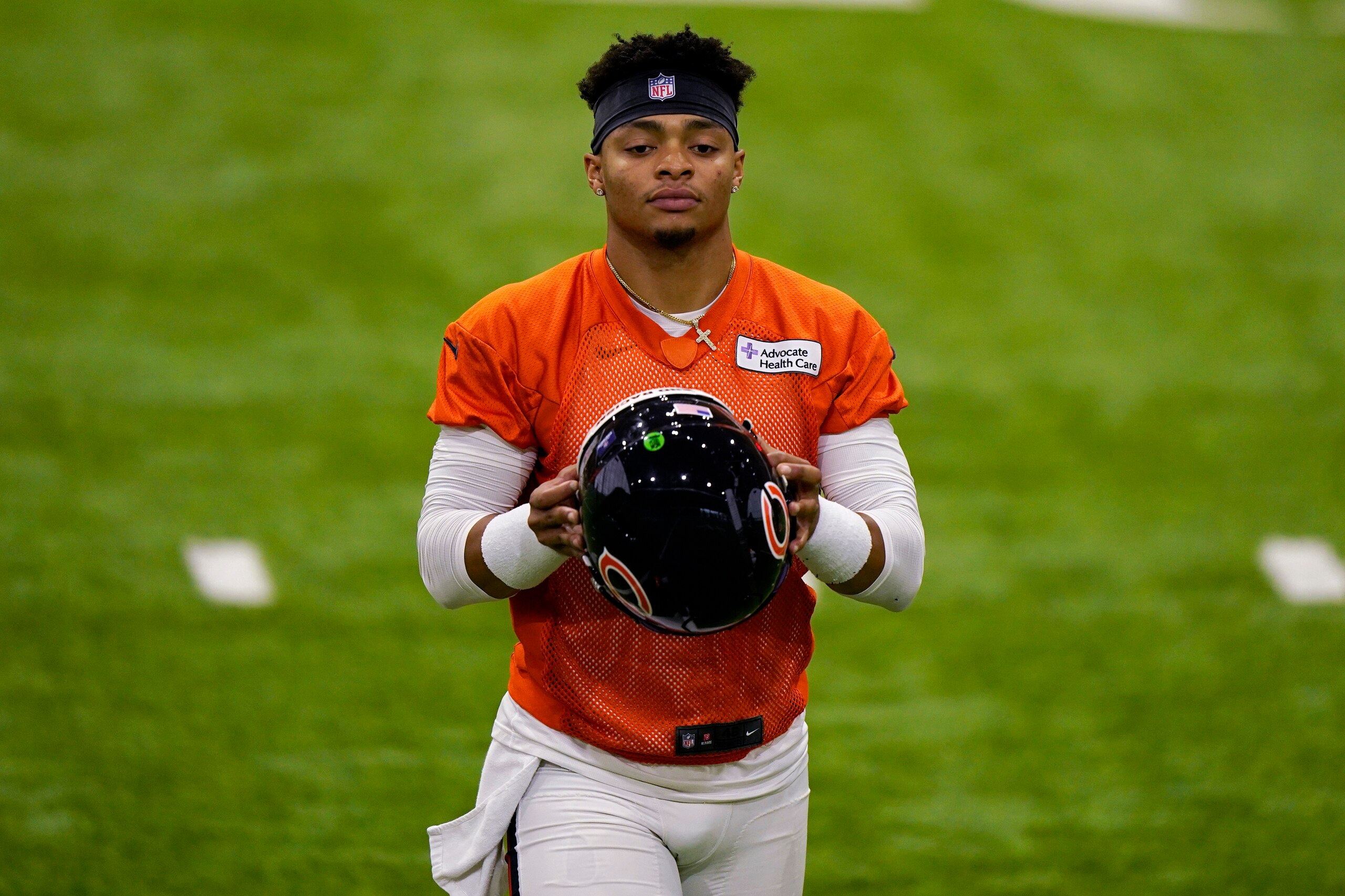 Chicago Bears quarterback Justin Fields walks on the field at the NFL football team's practice facility in Lake Forest, Ill., Wednesday, June 8, 2022. (AP Photo/Nam Y. Huh)
