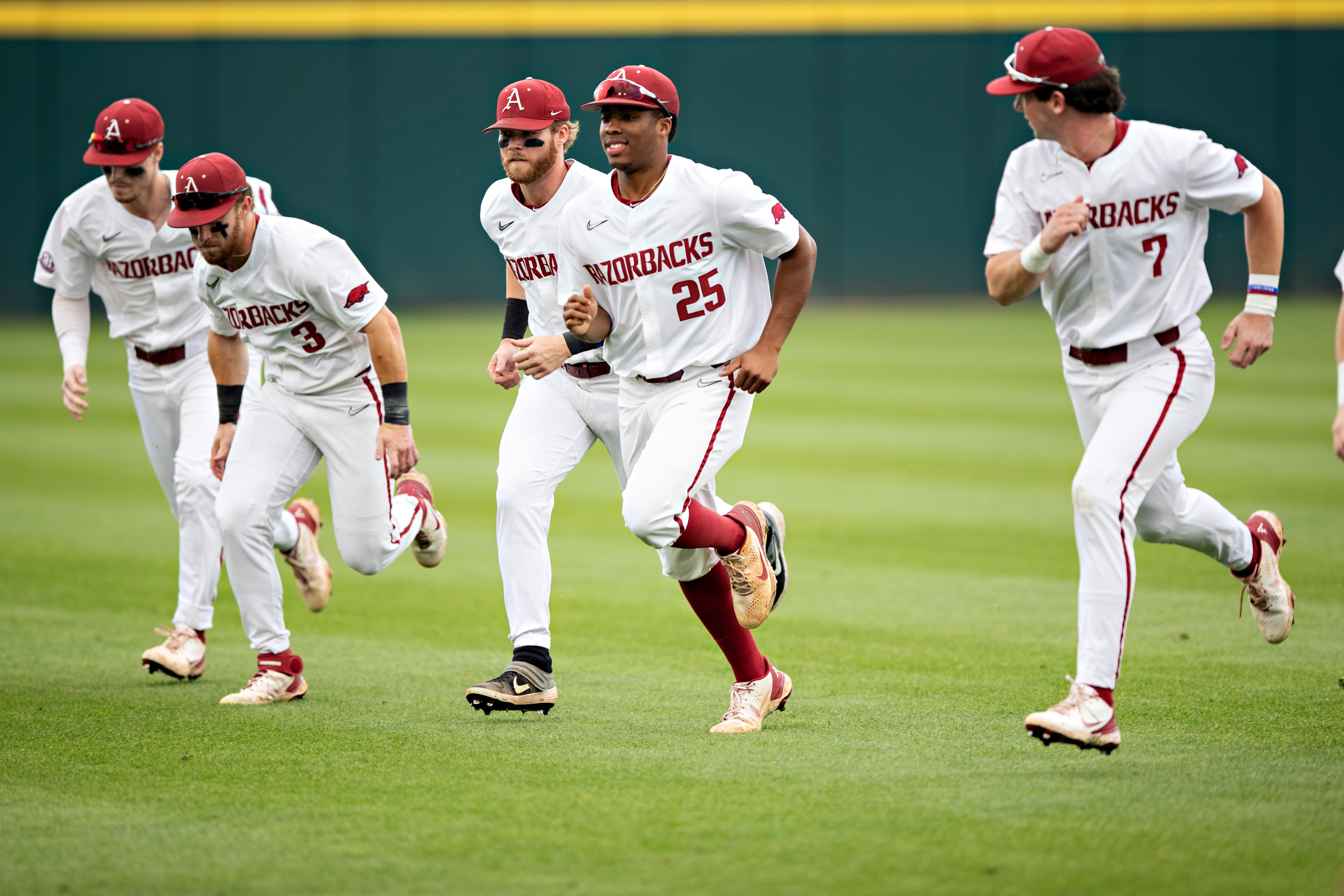 FAYETTEVILLE, ARKANSAS - JUNE 7: Cayden Wallace #7 and Christian Franklin #25 of the Arkansas Razorbacks warm up before a game against the Nebraska Cornhuskers at the NCAA Fayetteville Regional at Baum-Walker Stadium at George Cole Field on June 7, 2021 in Fayetteville, Arkansas. The Razorbacks defeated the Cornhuskers 6-2.  (Photo by Wesley Hitt/Getty Images)