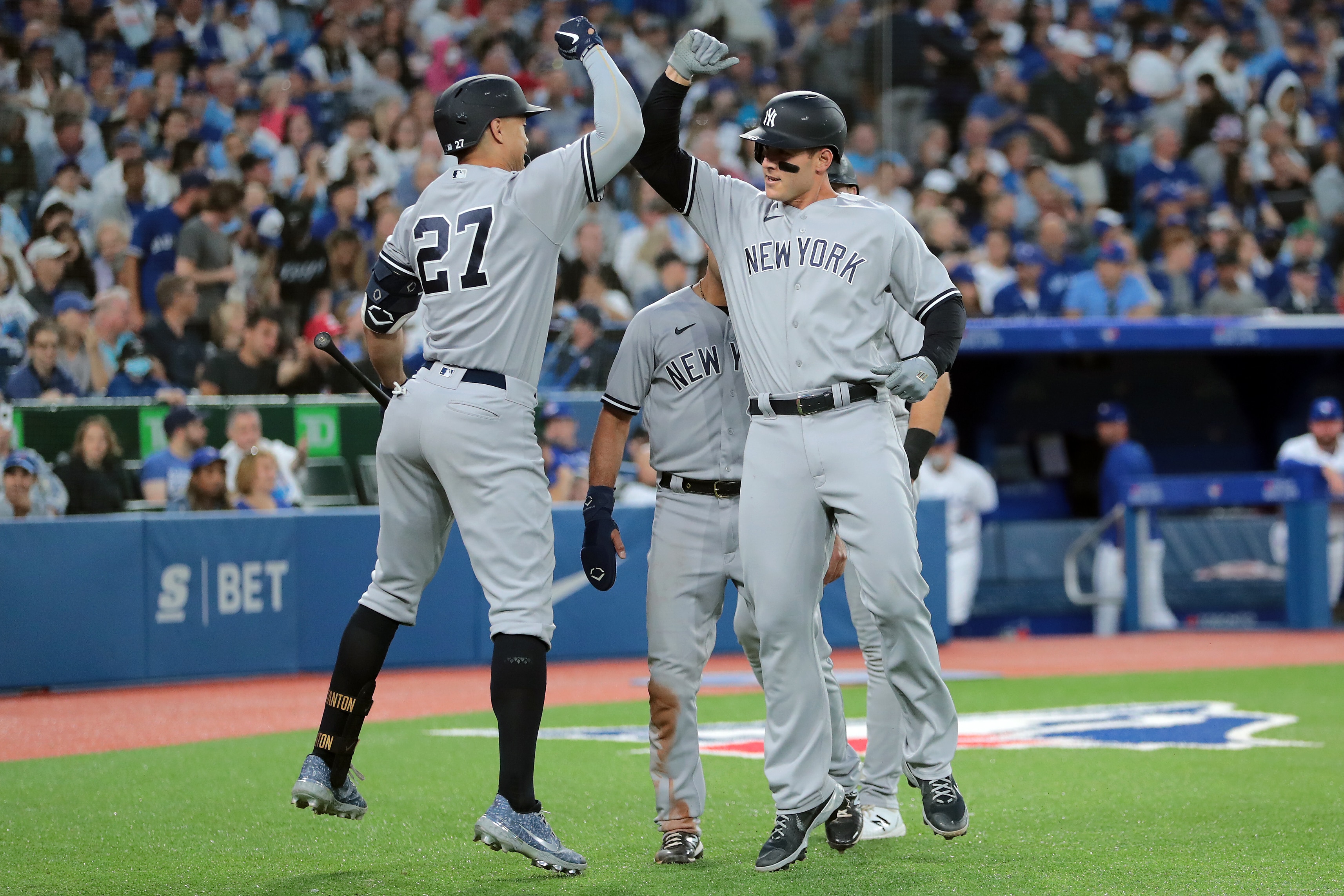 TORONTO, ON - JUNE 17:  Anthony Rizzo #48 of the New York Yankees and Giancarlo Stanton #27 celebrate Rizzos grand slam at the plate in the fifth inning of their MLB game against the Toronto Blue Jays at Rogers Centre on June 17, 2022 in Toronto, Canada. (Photo by Cole Burston/Getty Images)