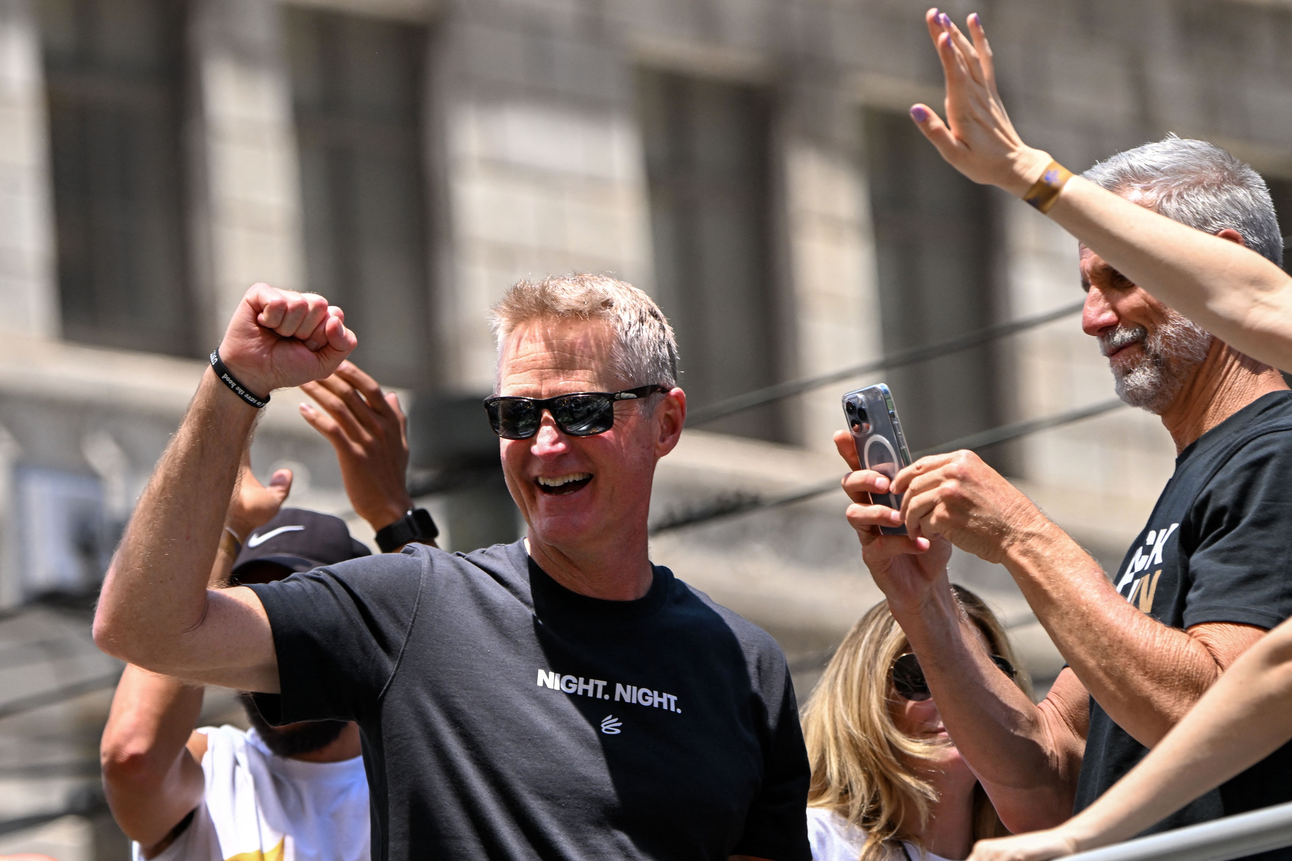 Head coach Steve Kerr (C) waves with coaching staff from a double decker bus during the Golden State Warriors NBA Championship victory parade along Market Street in San Francisco, California on June 20, 2022. (Photo by Patrick T. FALLON / AFP) (Photo by PATRICK T. FALLON/AFP via Getty Images)