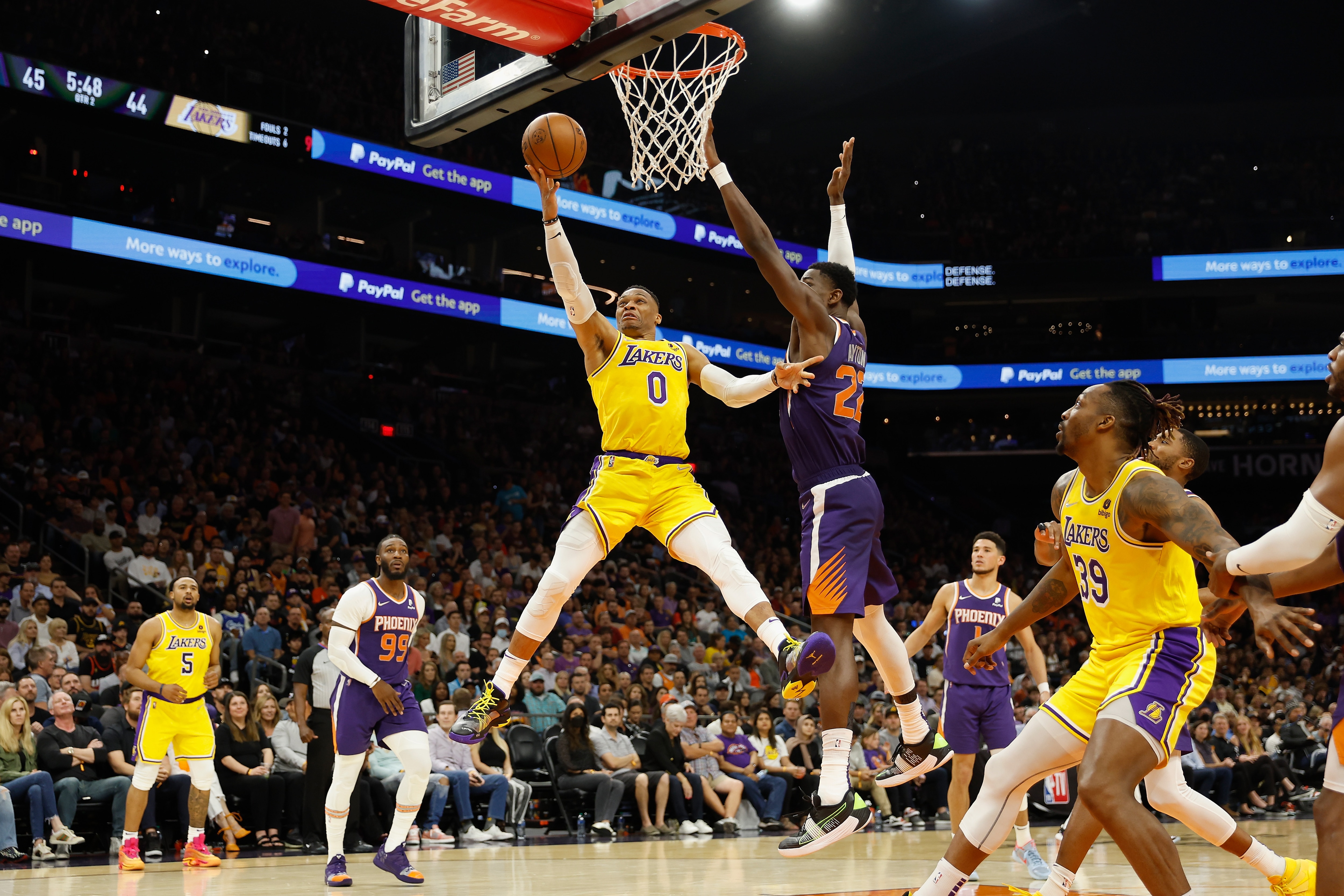 PHOENIX, ARIZONA - APRIL 05: Russell Westbrook #0 of the Los Angeles Lakers lays up a shot past Deandre Ayton #22 of the Phoenix Suns during the first half of the NBA game at Footprint Center on April 05, 2022 in Phoenix, Arizona.  The Suns defeated the Lakers 121-110.  NOTE TO USER: User expressly acknowledges and agrees that, by downloading and or using this photograph, User is consenting to the terms and conditions of the Getty Images License Agreement. (Photo by Christian Petersen/Getty Images)