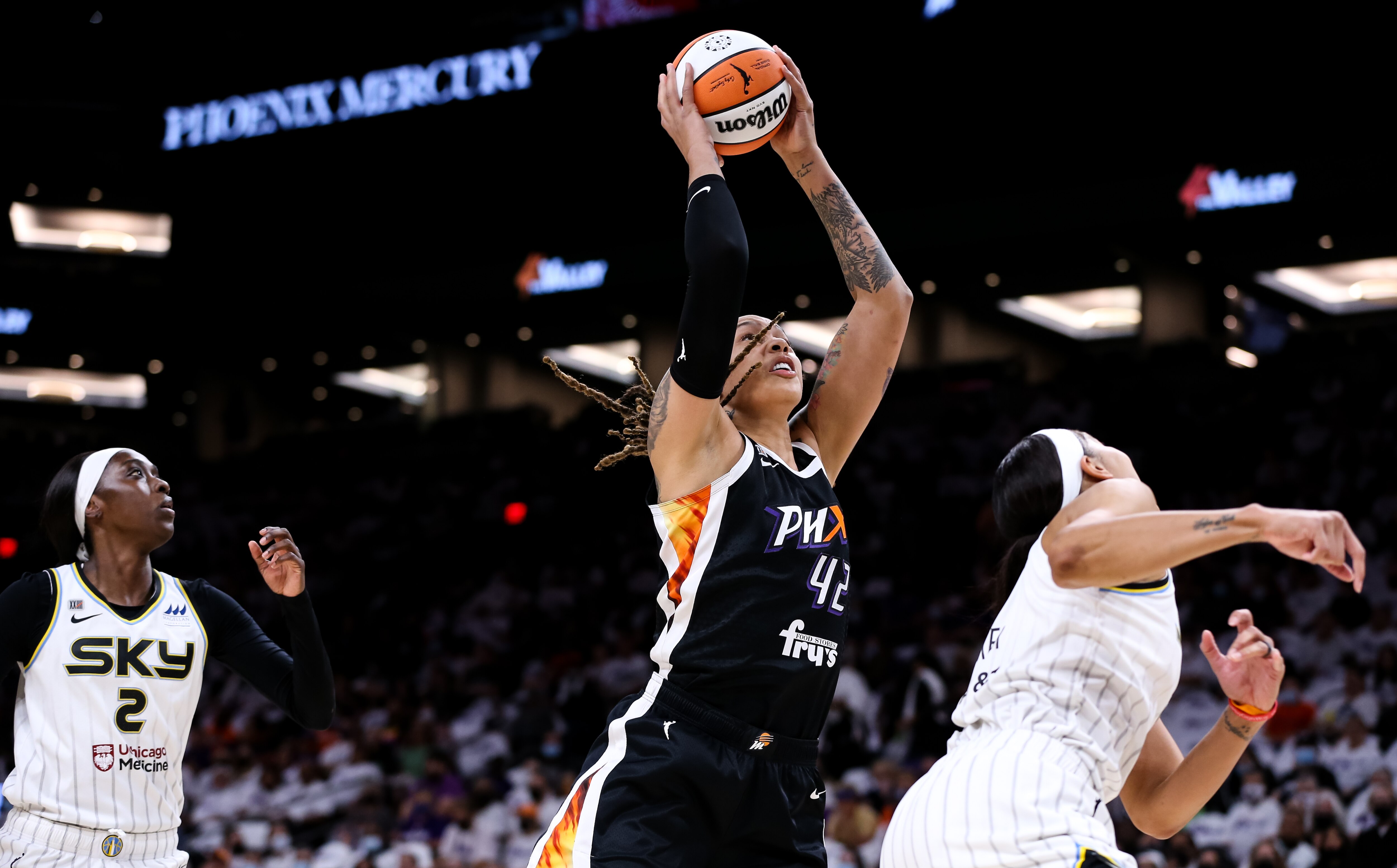 PHOENIX, ARIZONA - OCTOBER 10: Brittney Griner #42 of the Phoenix Mercury pulls down a rebound over Candace Parker #3 of the Chicago Sky and Kahleah Copper #2 of the Chicago Sky in the first half at Footprint Center on October 10, 2021 in Phoenix, Arizona. NOTE TO USER: User expressly acknowledges and agrees that, by downloading and or using this photograph, User is consenting to the terms and conditions of the Getty Images License Agreement. (Photo by Mike Mattina/Getty Images)