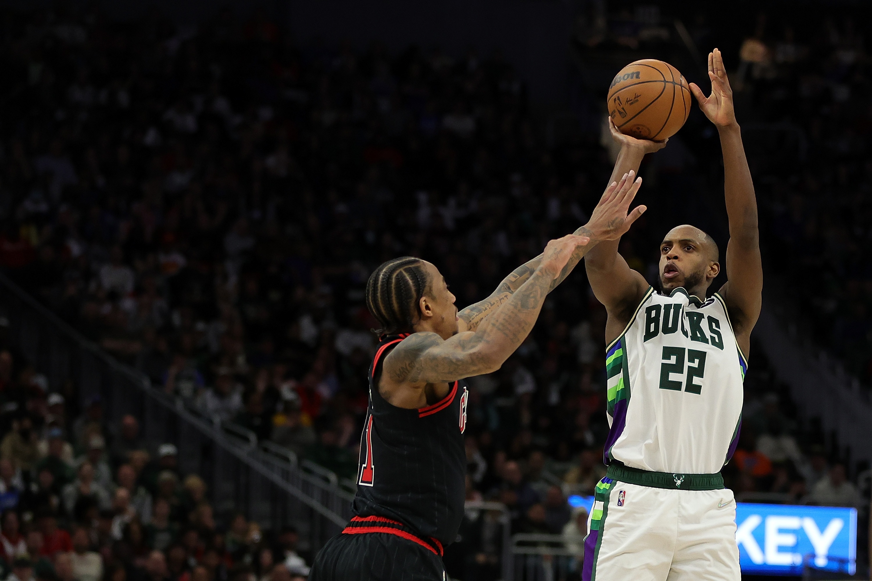 MILWAUKEE, WISCONSIN - APRIL 17: Khris Middleton #22 of the Milwaukee Bucks shoots over DeMar DeRozan #11 of the Chicago Bulls during the second half of Game One of the Eastern Conference First Round Playoffs at Fiserv Forum on April 17, 2022 in Milwaukee, Wisconsin. NOTE TO USER: User expressly acknowledges and agrees that, by downloading and or using this photograph, User is consenting to the terms and conditions of the Getty Images License Agreement. (Photo by Stacy Revere/Getty Images)