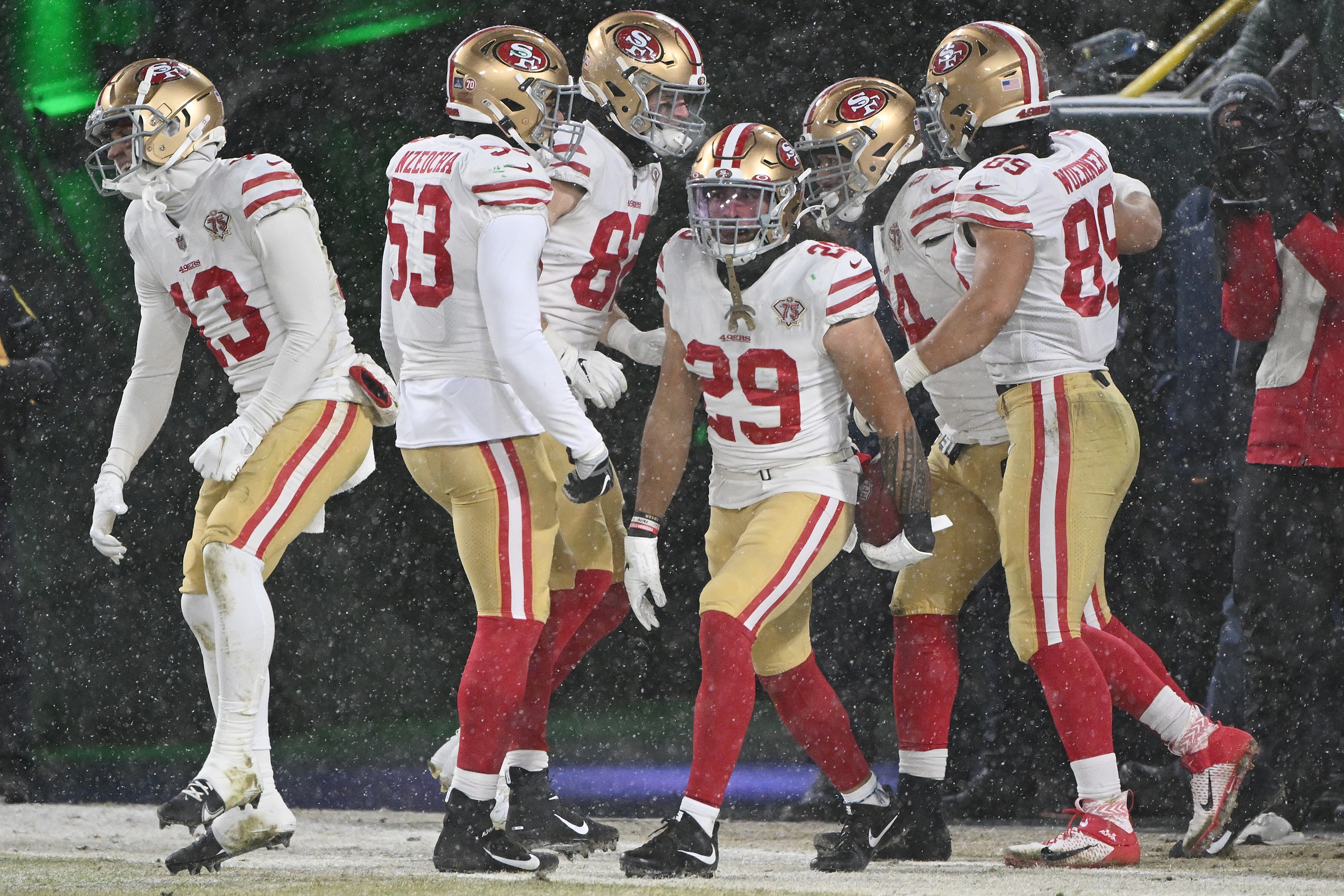GREEN BAY, WISCONSIN - JANUARY 22:  Safety Talanoa Hufanga #29 of the San Francisco 49ers is congratulated by teammates after recovering a blocked punt and running the ball in for a touchdown during the 4th quarter of the NFC Divisional Playoff game against the Green Bay Packers at Lambeau Field on January 22, 2022 in Green Bay, Wisconsin. (Photo by Quinn Harris/Getty Images)