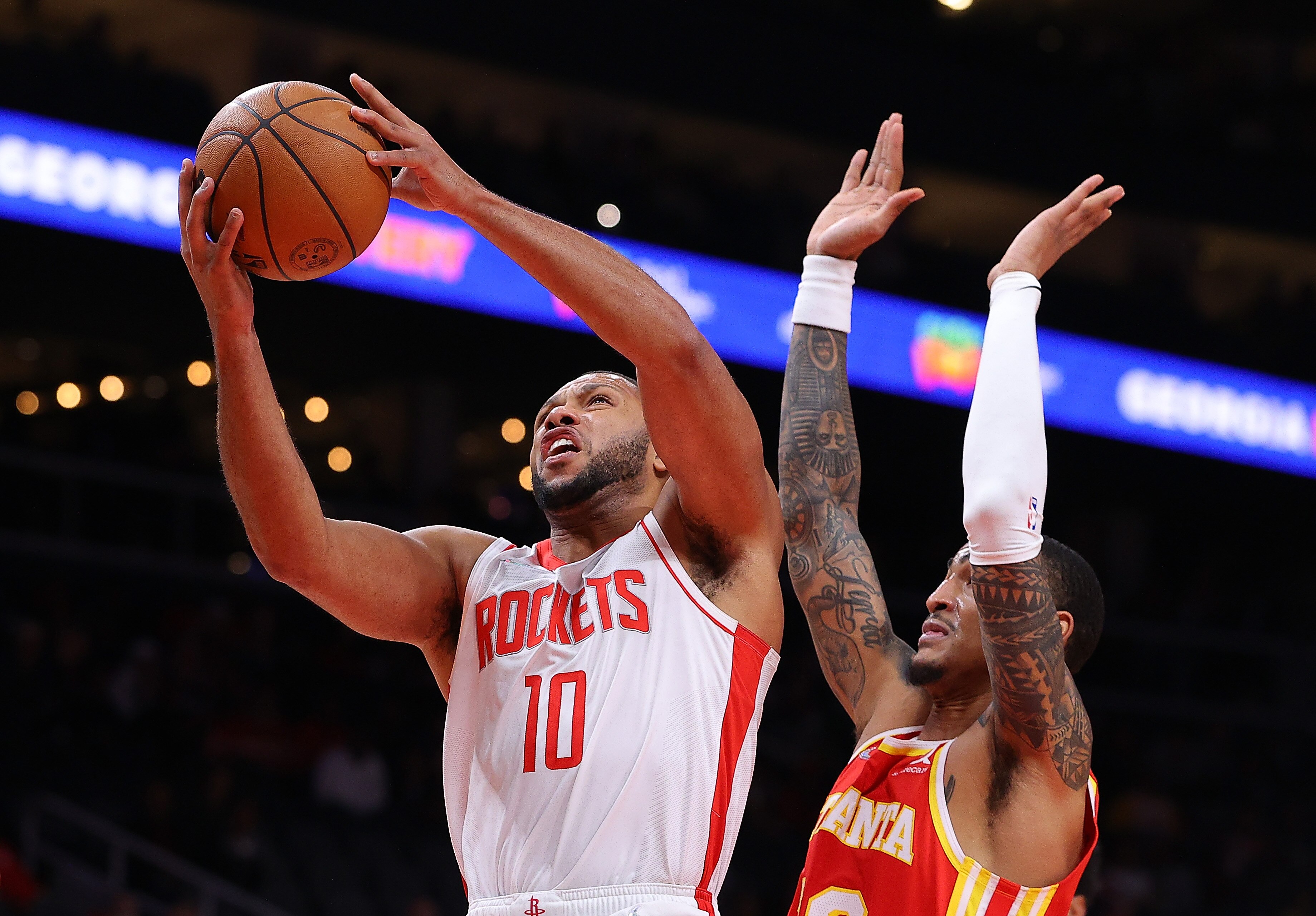 ATLANTA, GEORGIA - DECEMBER 13:  Eric Gordon #10 of the Houston Rockets draws a foul from John Collins #20 of the Atlanta Hawks during the first half at State Farm Arena on December 13, 2021 in Atlanta, Georgia.  NOTE TO USER: User expressly acknowledges and agrees that, by downloading and or using this photograph, User is consenting to the terms and conditions of the Getty Images License Agreement.  (Photo by Kevin C. Cox/Getty Images)