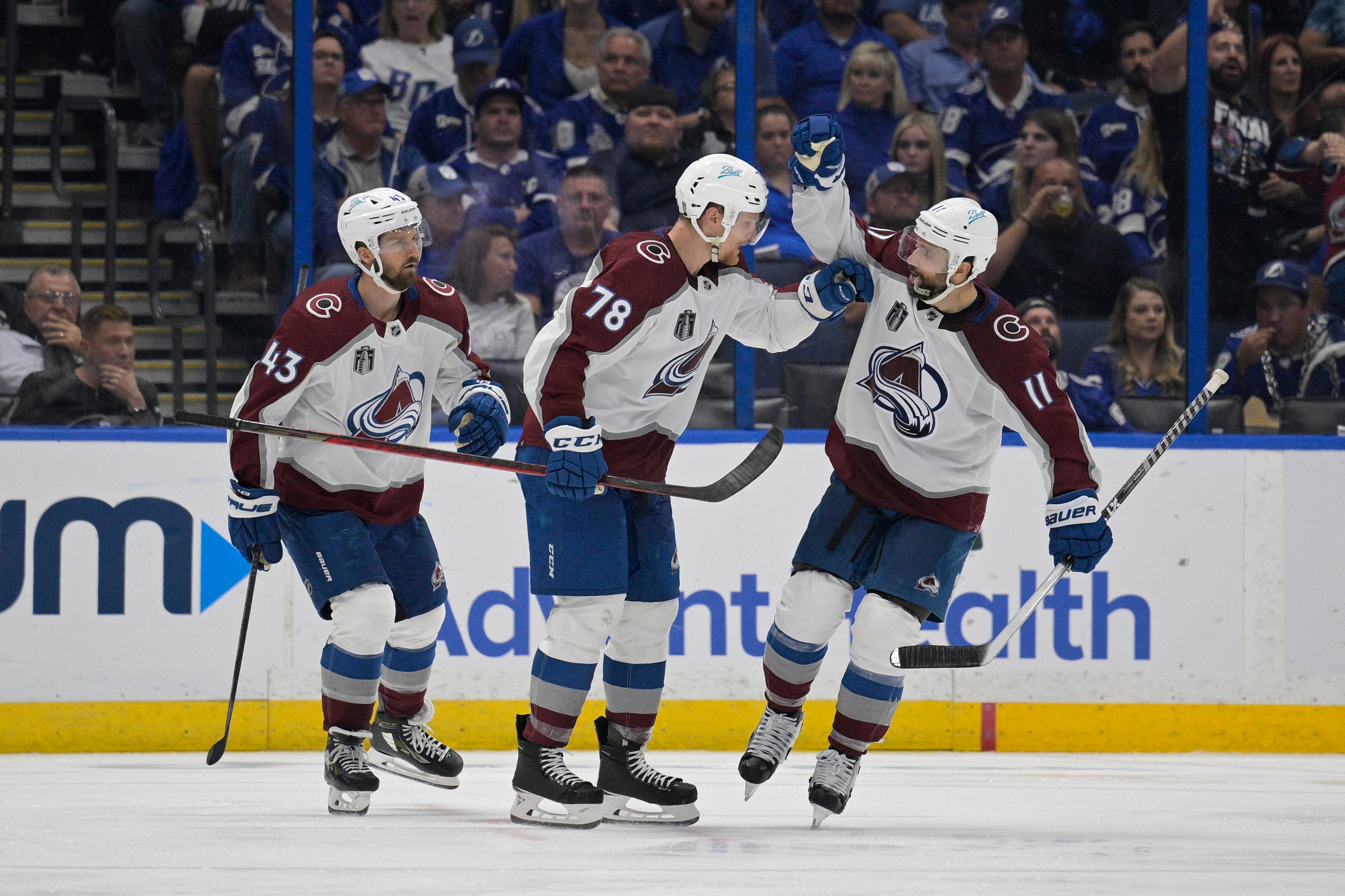 Colorado Avalanche center Andrew Cogliano (11) is congratulated by teammate Nico Sturm (78) after scoring during the third period of Game 4 of the NHL hockey Stanley Cup Finals against the Tampa Bay Lightning on Wednesday, June 22, 2022, in Tampa, Fla. (AP Photo/Phelan Ebenhack)