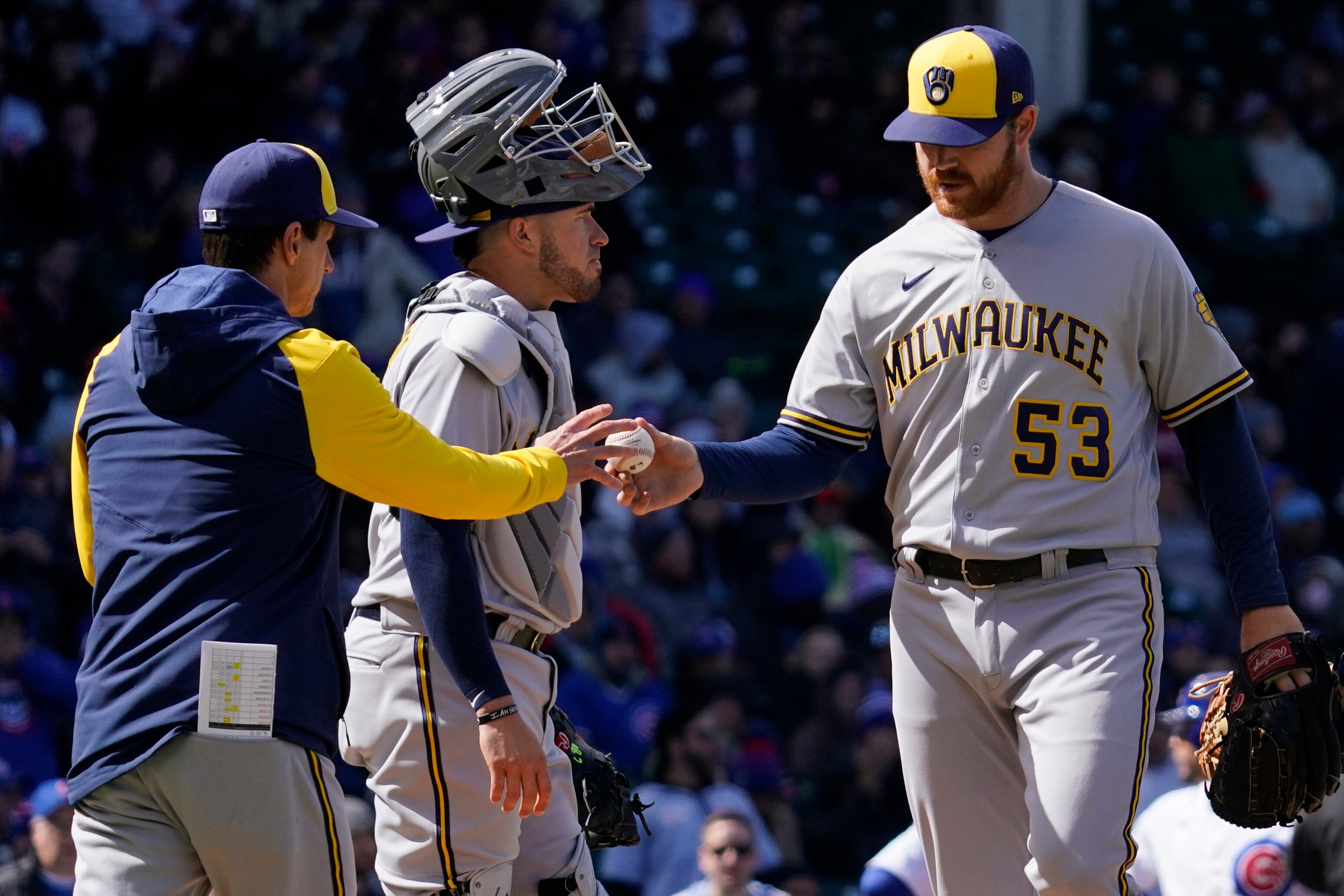 Milwaukee Brewers manager Craig Counsell, left, takes the ball from starting pitcher Brandon Woodruff during the fourth inning of a baseball game against the Chicago Cubs in Chicago, Saturday, April 9, 2022. (AP Photo/Nam Y. Huh)