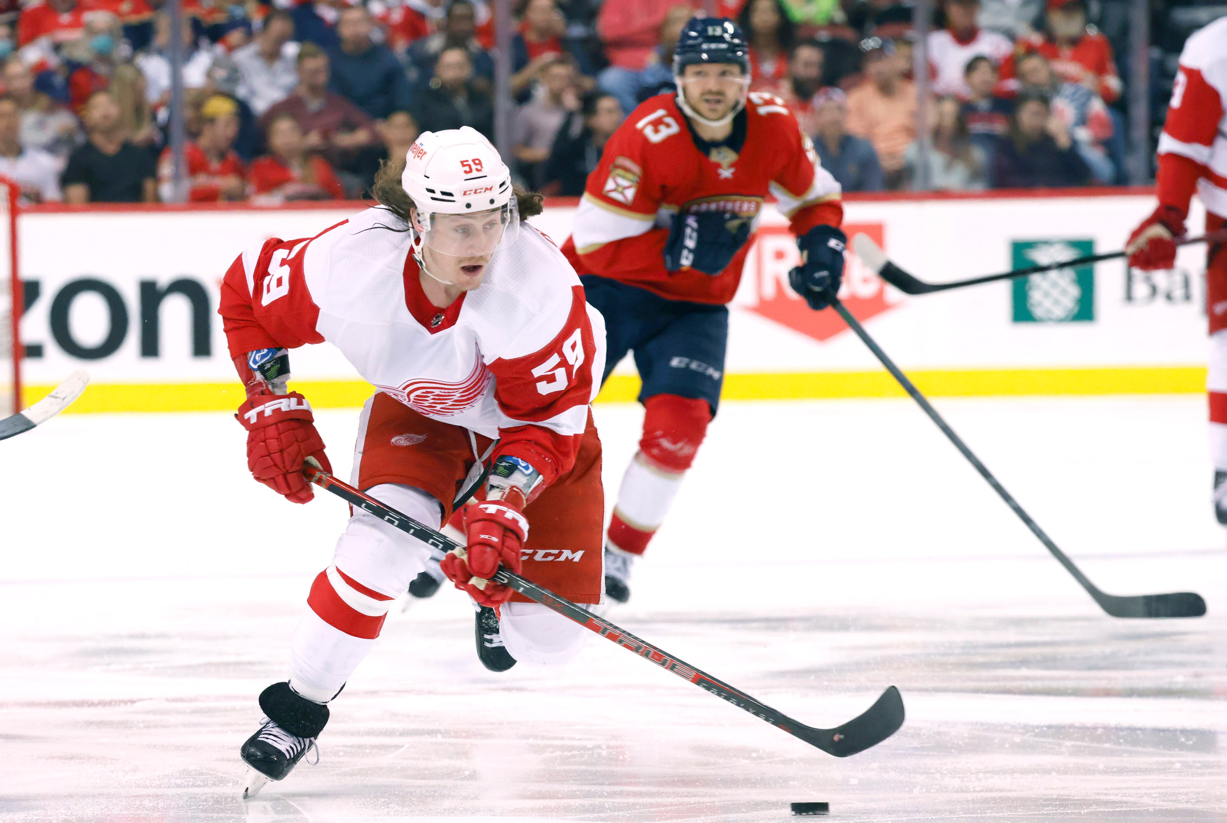 Detroit Red Wings left wing Tyler Bertuzzi (59) skates downice as Florida Panthers center Sam Reinhart (13) pursues during the third period of an NHL hockey game Thursday, April 21, 2022, in Sunrise, Fla. (AP Photo/Reinhold Matay)