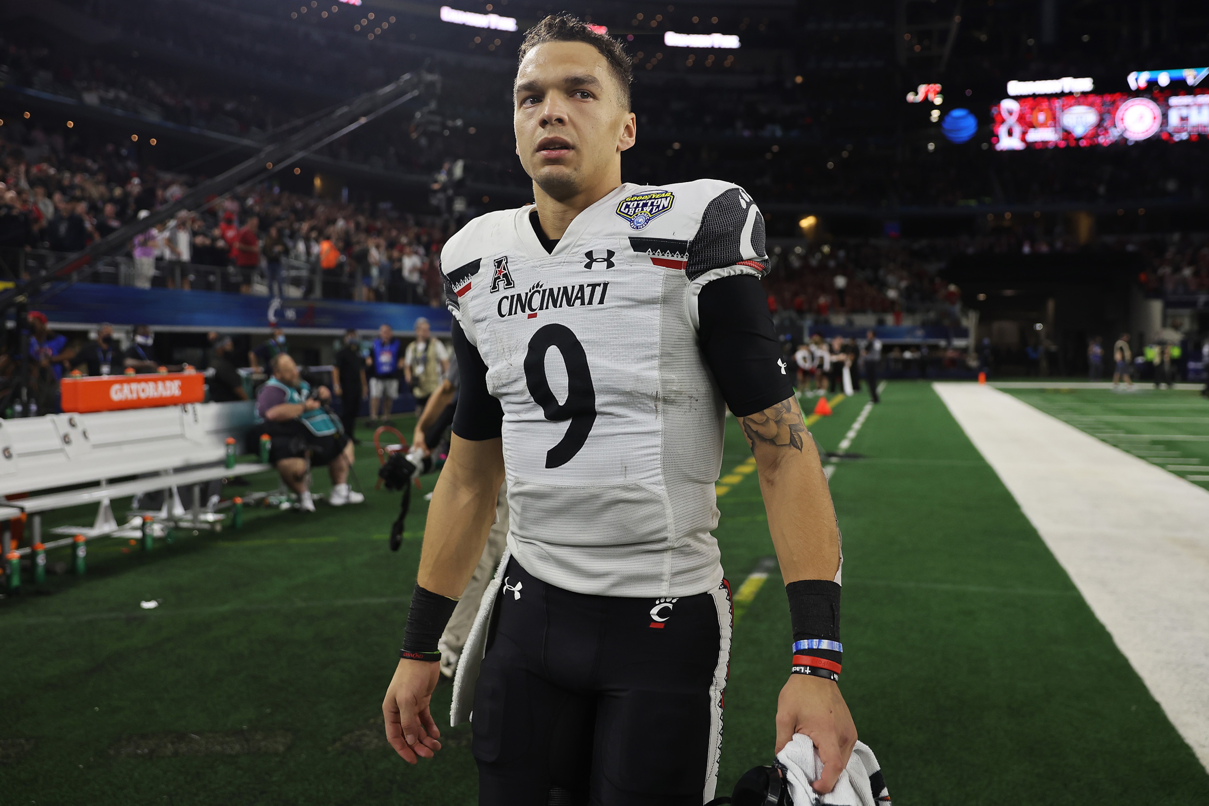 ARLINGTON, TEXAS - DECEMBER 31: Desmond Ridder #9 of the Cincinnati Bearcats walks off the field after losing to the Alabama Crimson Tide 27-6 in the Goodyear Cotton Bowl Classic for the College Football Playoff semifinal game at AT&T Stadium on December 31, 2021 in Arlington, Texas. (Photo by Matthew Stockman/Getty Images) ARLINGTON, TEXAS - DECEMBER 31: Desmond Ridder #9 of the Cincinnati Bearcats walks off the field after losing to the Alabama Crimson Tide 27-6 in the Goodyear Cotton Bowl Classic for the College Football Playoff semifinal game at AT&T Stadium on December 31, 2021 in Arlington, Texas. (Photo by Matthew Stockman/Getty Images)