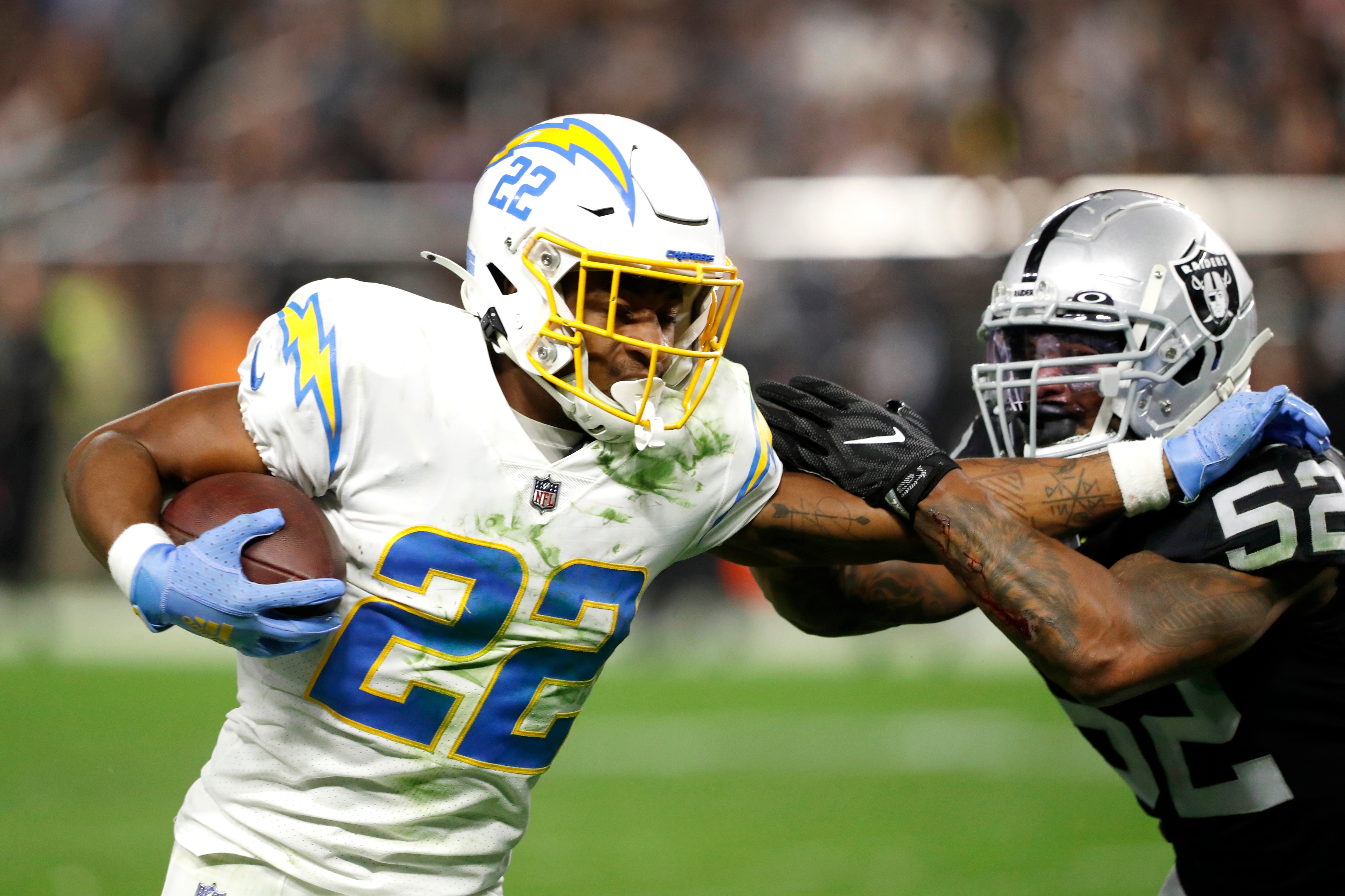 LAS VEGAS, NEVADA - JANUARY 09: Running back Justin Jackson #22 of the Los Angeles Chargers is tackled by linebacker Denzel Perryman #52 of the Las Vegas Raiders at Allegiant Stadium on January 09, 2022 in Las Vegas, Nevada. (Photo by Steve Marcus/Getty Images)