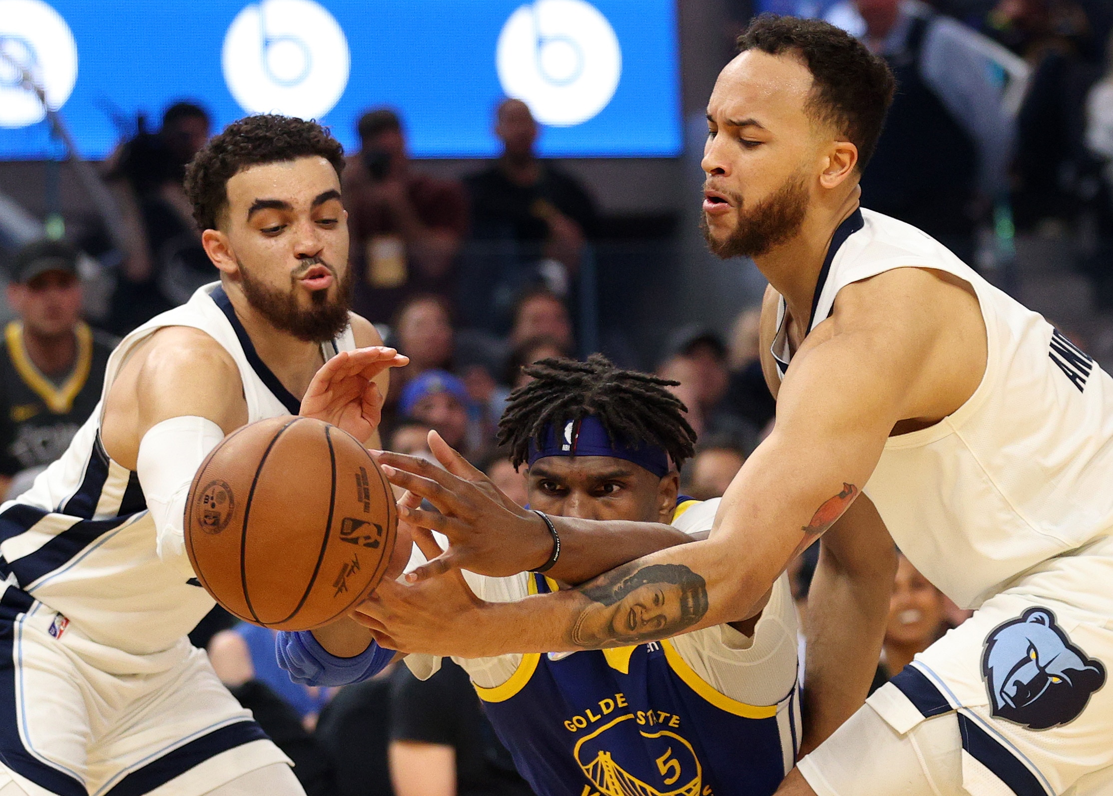 SAN FRANCISCO, CALIFORNIA - MAY 13:  Kevon Looney #5 of the Golden State Warriors reaches for the ball against Tyus Jones #21 and Kyle Anderson #1 of the Memphis Grizzlies during the first quarter in Game Six of the 2022 NBA Playoffs Western Conference Semifinals at Chase Center on May 13, 2022 in San Francisco, California. NOTE TO USER: User expressly acknowledges and agrees that, by downloading and/or using this photograph, User is consenting to the terms and conditions of the Getty Images License Agreement. (Photo by Ezra Shaw/Getty Images)