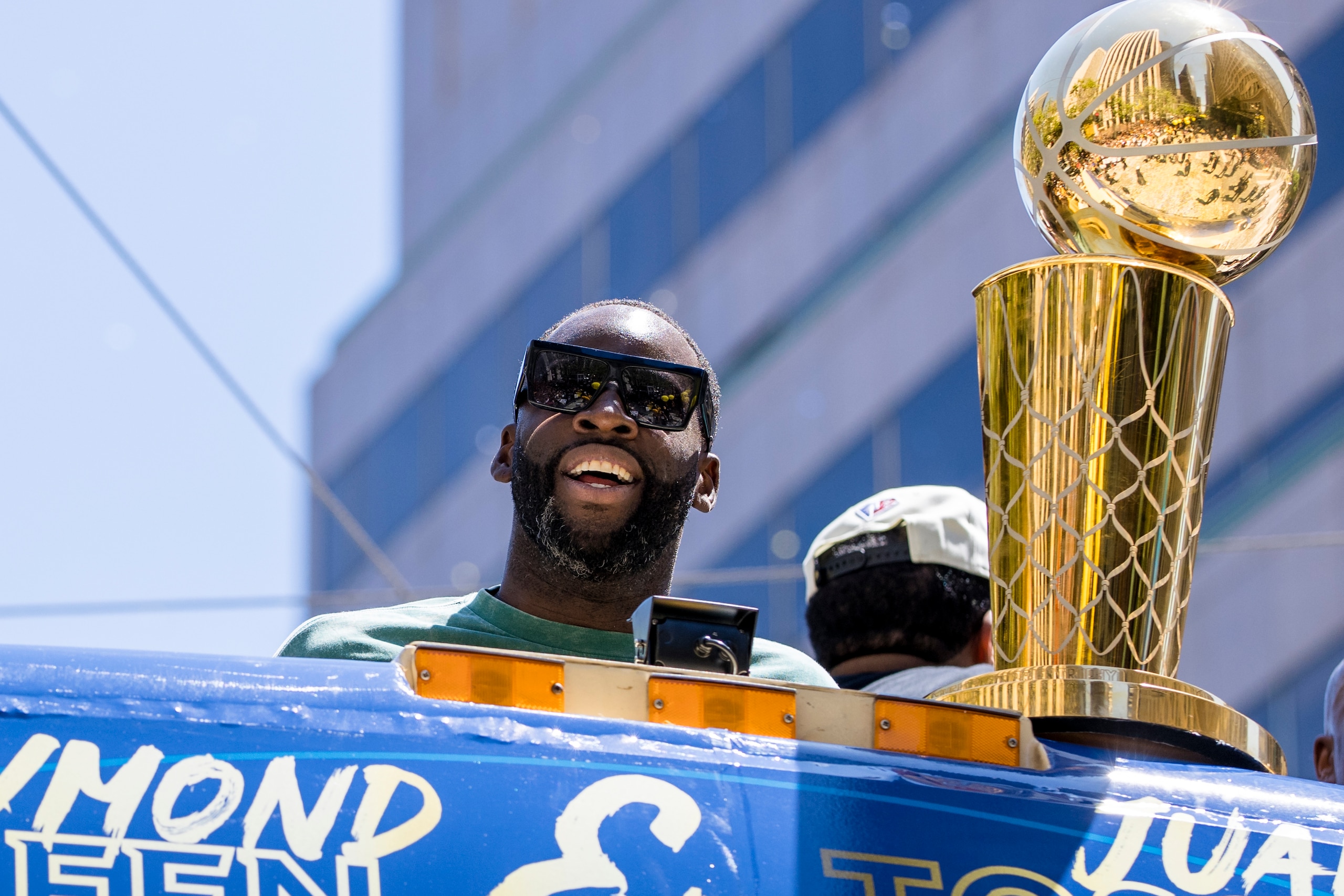 Golden State Warriors' Draymond Green stands next to the Larry O'Brien trophy during the NBA Championship parade in San Francisco, Monday, June 20, 2022, in San Francisco. (AP Photo/John Hefti)