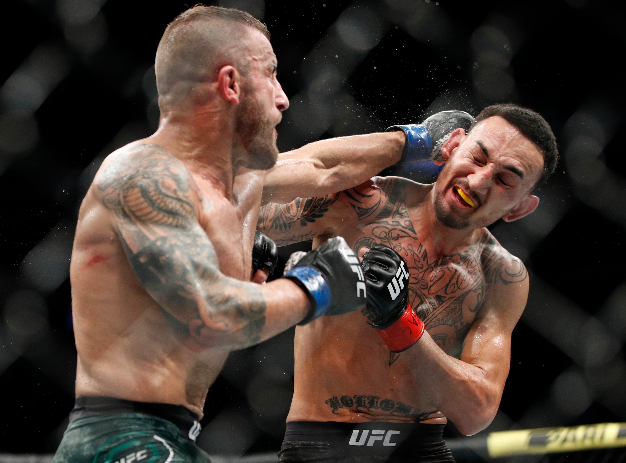Alexander Volkanovski hits Max Holloway in a mixed martial arts featherweight championship bout at UFC 245, Saturday, Dec. 14, 2019, in Las Vegas. (AP Photo/John Locher)