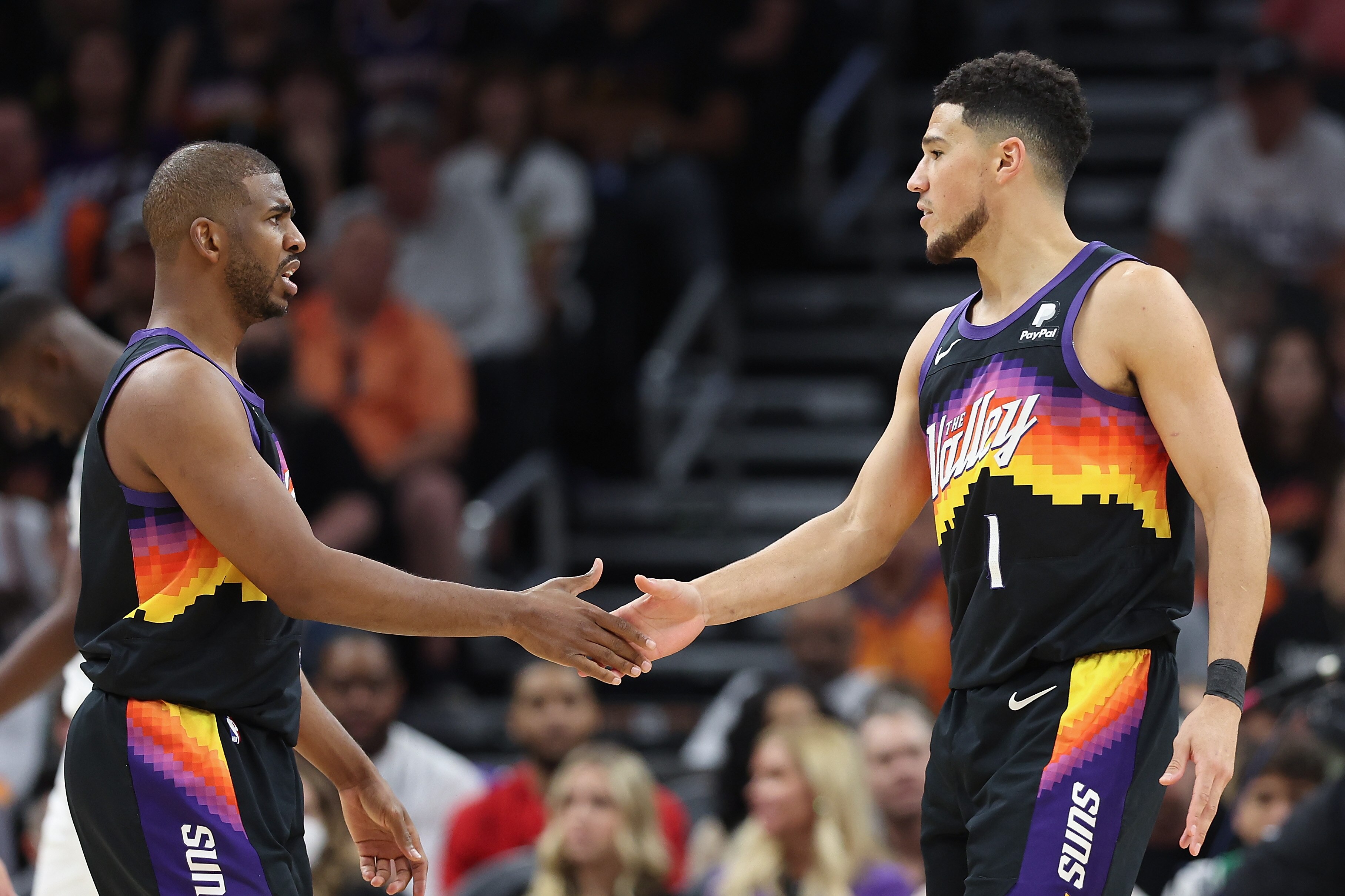 PHOENIX, ARIZONA - MAY 15: Chris Paul #3 and Devin Booker #1 of the Phoenix Suns shake hands during the second half of Game Seven of the Western Conference Second Round NBA Playoffs at Footprint Center on May 15, 2022 in Phoenix, Arizona.  The Mavericks defeated the Suns 123-90.  NOTE TO USER: User expressly acknowledges and agrees that, by downloading and or using this photograph, User is consenting to the terms and conditions of the Getty Images License Agreement. (Photo by Christian Petersen/Getty Images)