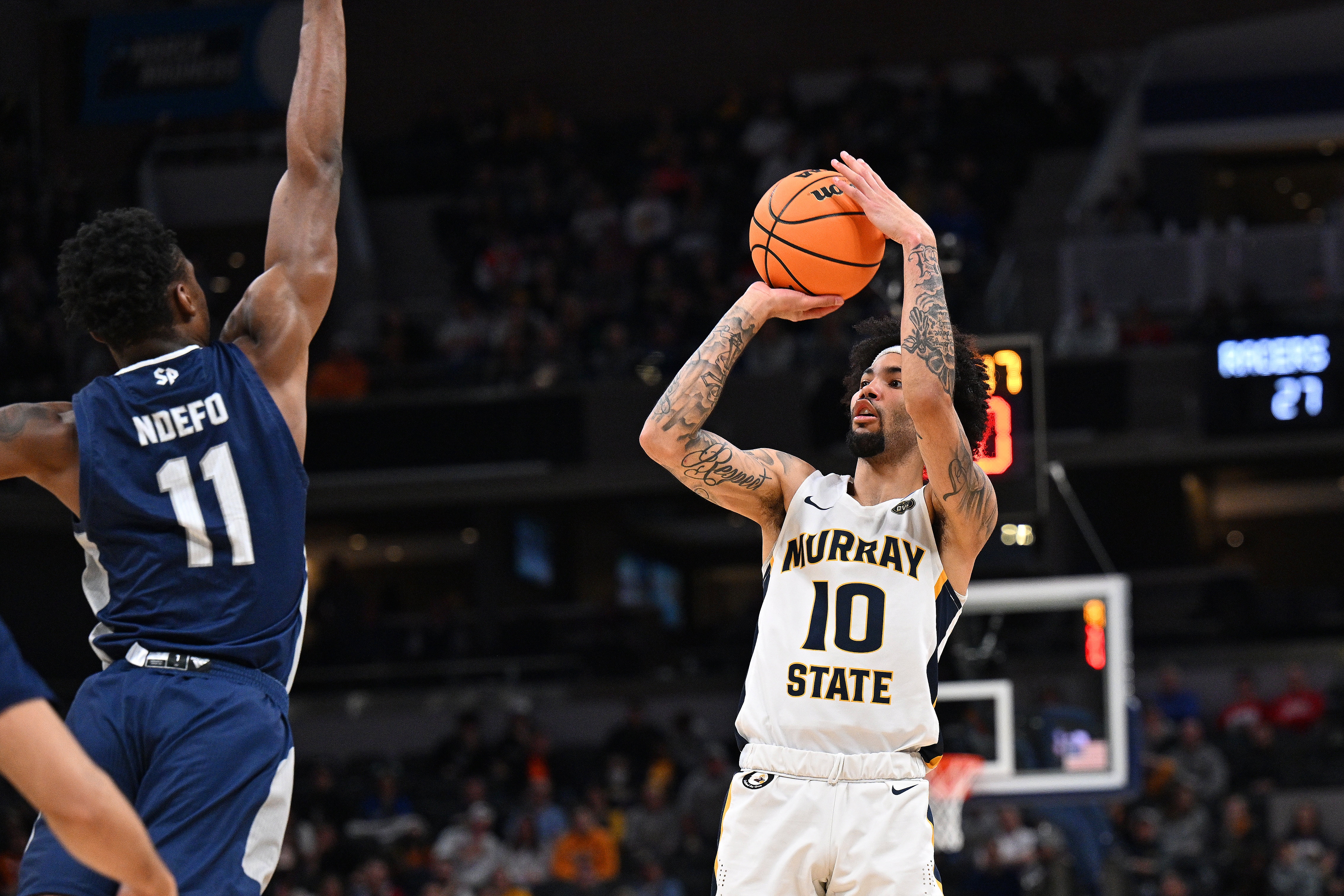 INDIANAPOLIS, IN - MARCH 19: Tevin Brown #10 of the Murray State Racers shoots while KC Ndefo #11 of the St. Peter's Peacocks defends during second half action in the second round of the 2022 NCAA Men's Basketball Tournament held at Gainbridge Fieldhouse on March 19, 2022 in Indianapolis, Indiana. Michigan won 76-68. (Photo by Jamie Sabau/NCAA Photos via Getty Images)