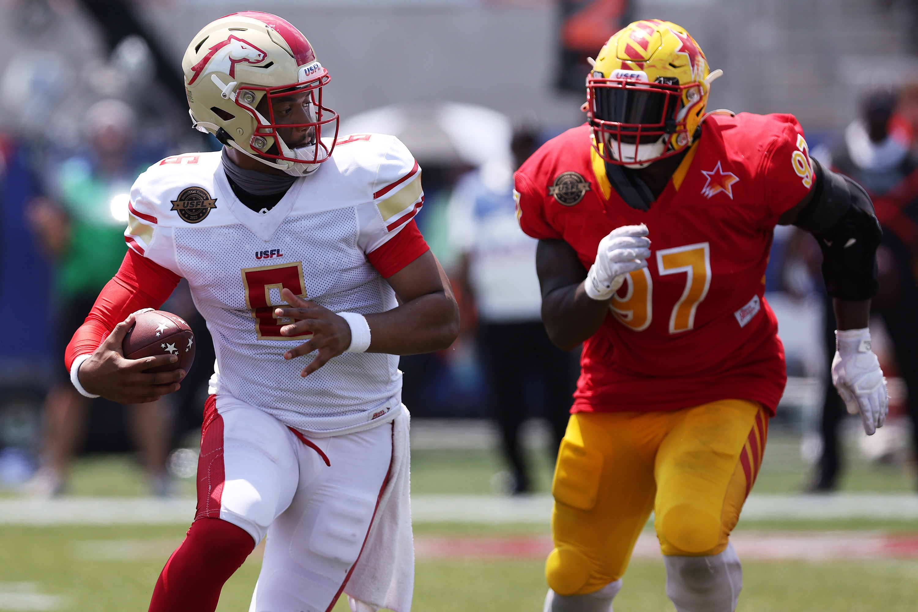 BIRMINGHAM, ALABAMA - MAY 15: J'Mar Smith #6 of Birmingham Stallions runs with the ball as Chris Nelson #97 of Philadelphia Stars runs to defend in the fourth quarter of the game at Protective Stadium on May 15, 2022 in Birmingham, Alabama. (Photo by Tom Pennington/USFL/Getty Images)