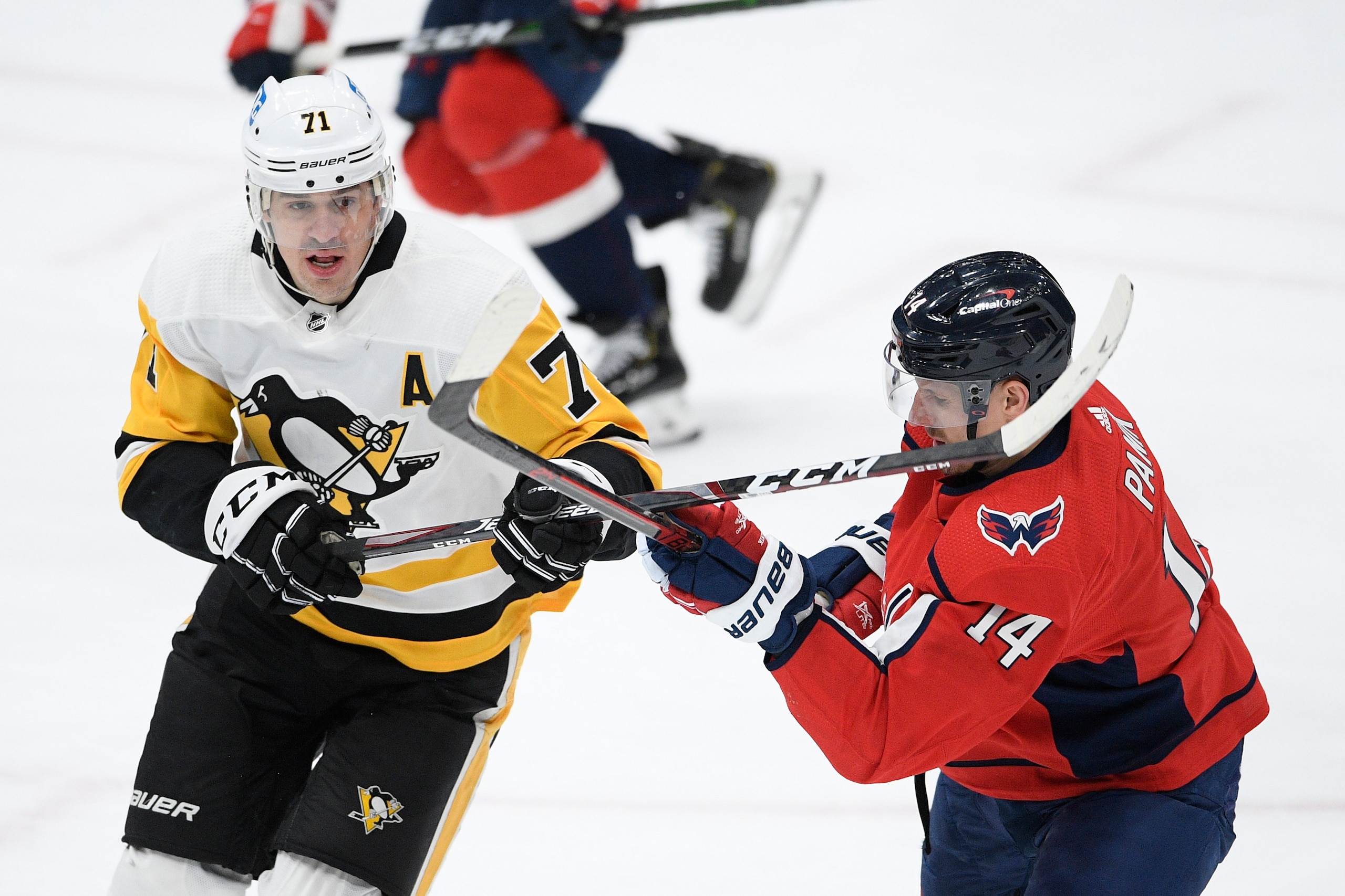 Pittsburgh Penguins center Evgeni Malkin (71) and Washington Capitals right wing Richard Panik (14) battle during the first period of an NHL hockey game, Thursday, Feb. 25, 2021, in Washington. (AP Photo/Nick Wass)