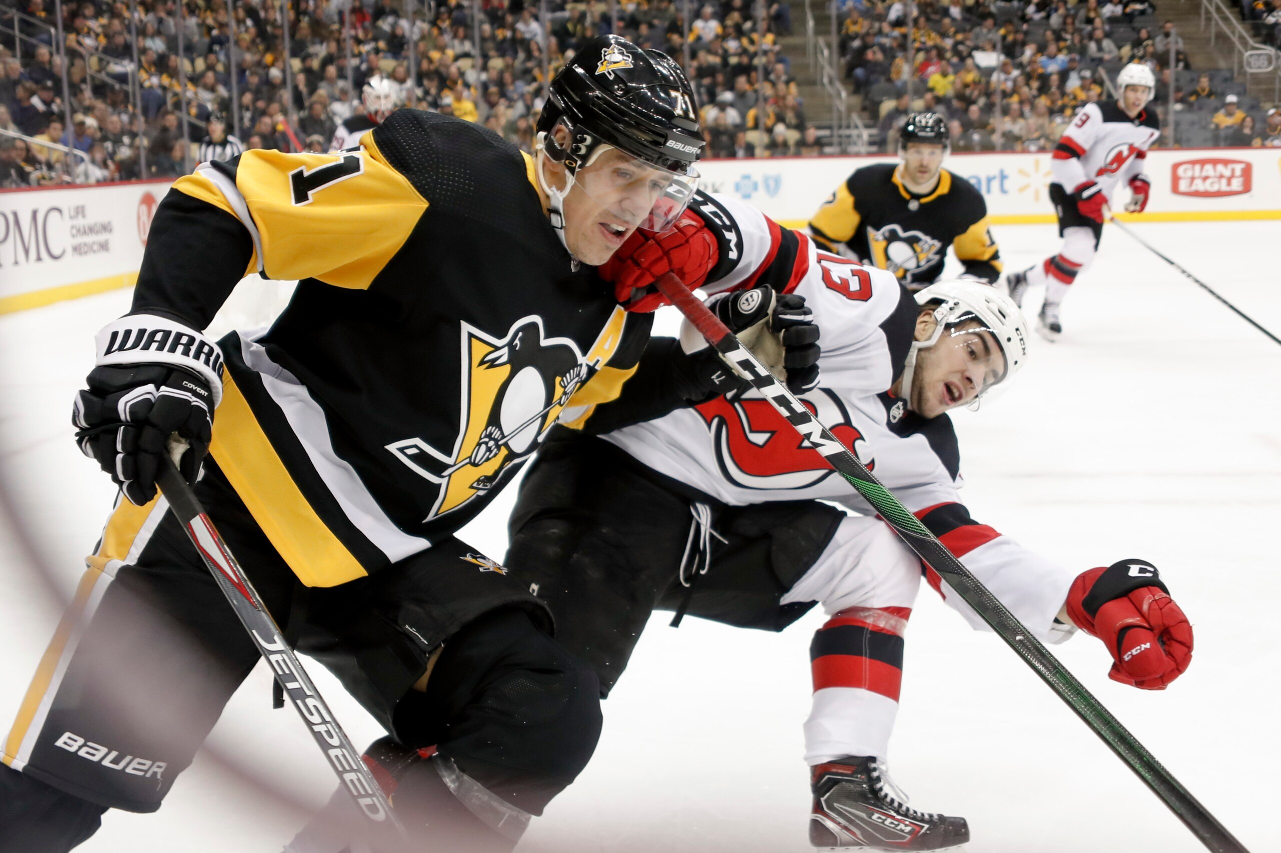 Pittsburgh Penguins' Evgeni Malkin (71) and New Jersey Devils' Nico Hischier (13) chase after the puck during the second period of an NHL hockey game, Friday, Nov. 22, 2019, in Pittsburgh. (AP Photo/Keith Srakocic)