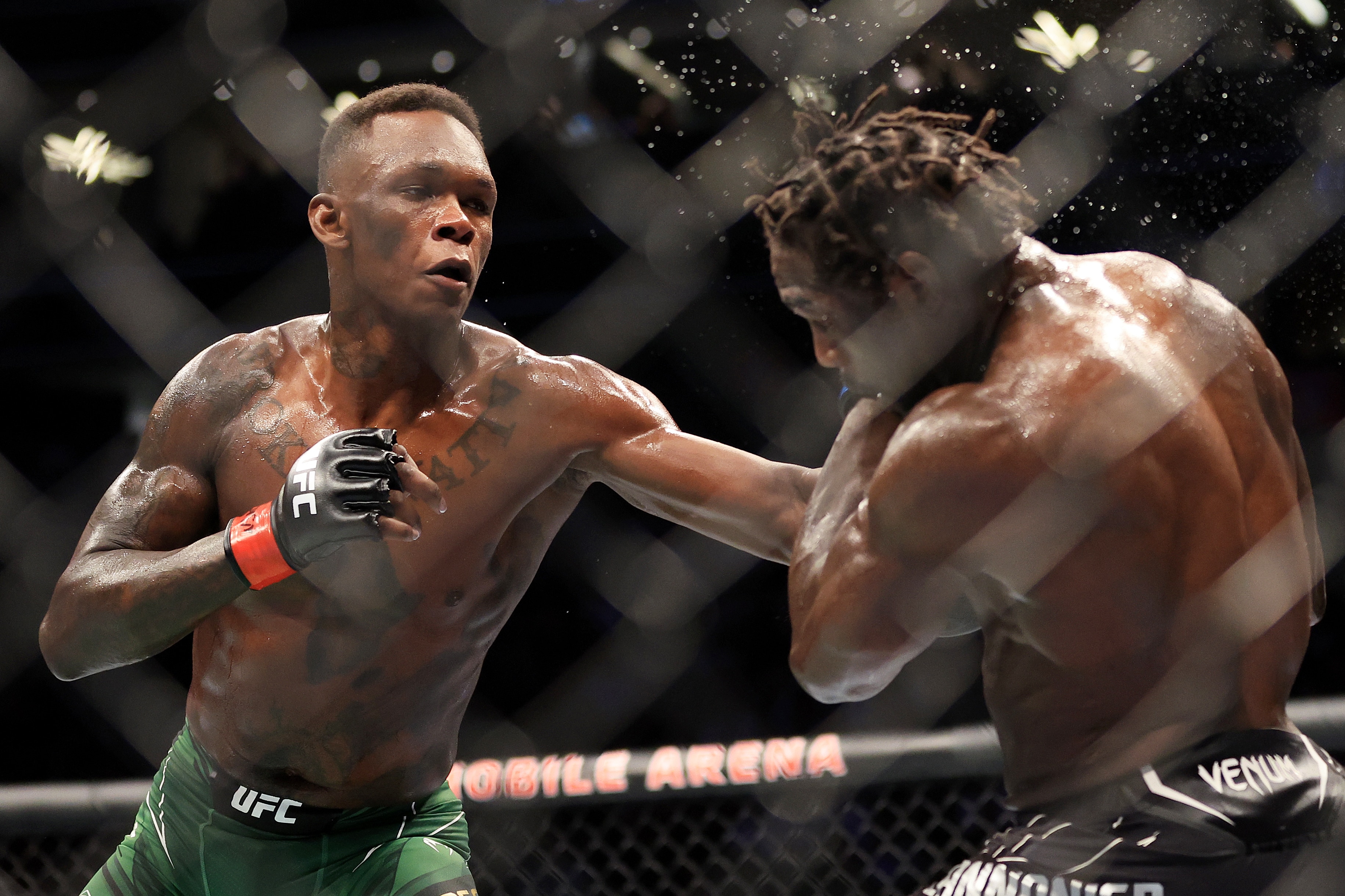 LAS VEGAS, NEVADA - JULY 02: Israel Adesanya (L) of Nigeria punches Jared Cannonier in their middleweight title bout during UFC 276 at T-Mobile Arena on July 02, 2022 in Las Vegas, Nevada. (Photo by Carmen Mandato/Getty Images)