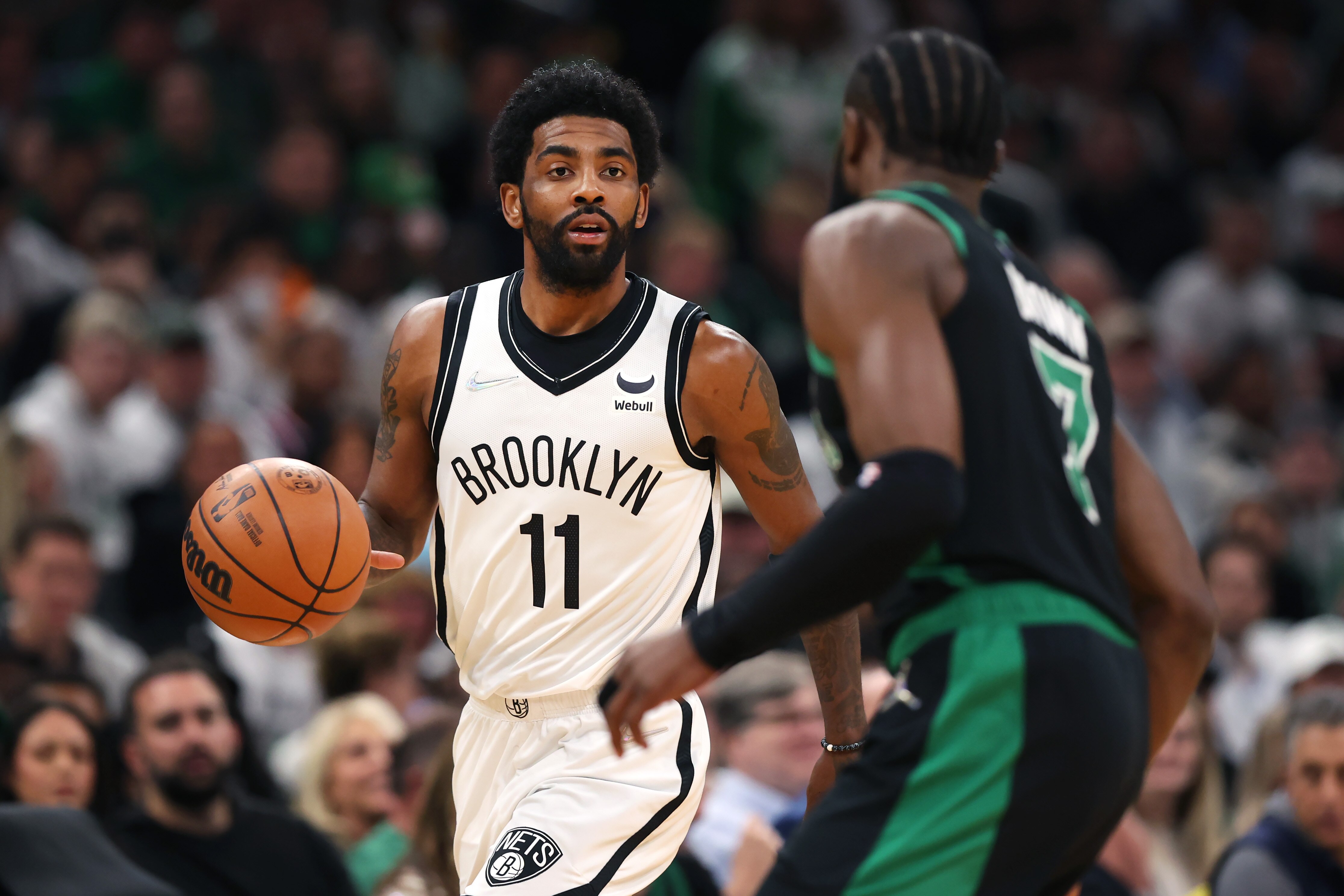BOSTON, MASSACHUSETTS - APRIL 17: Kyrie Irving #11 of the Brooklyn Nets dribbles downcourt against Jaylen Brown #7 of the Boston Celtics during the first quarter of Round 1 Game 1 of the 2022 NBA Eastern Conference Playoffs at TD Garden on April 17, 2022 in Boston, Massachusetts. (Photo by Maddie Meyer/Getty Images)