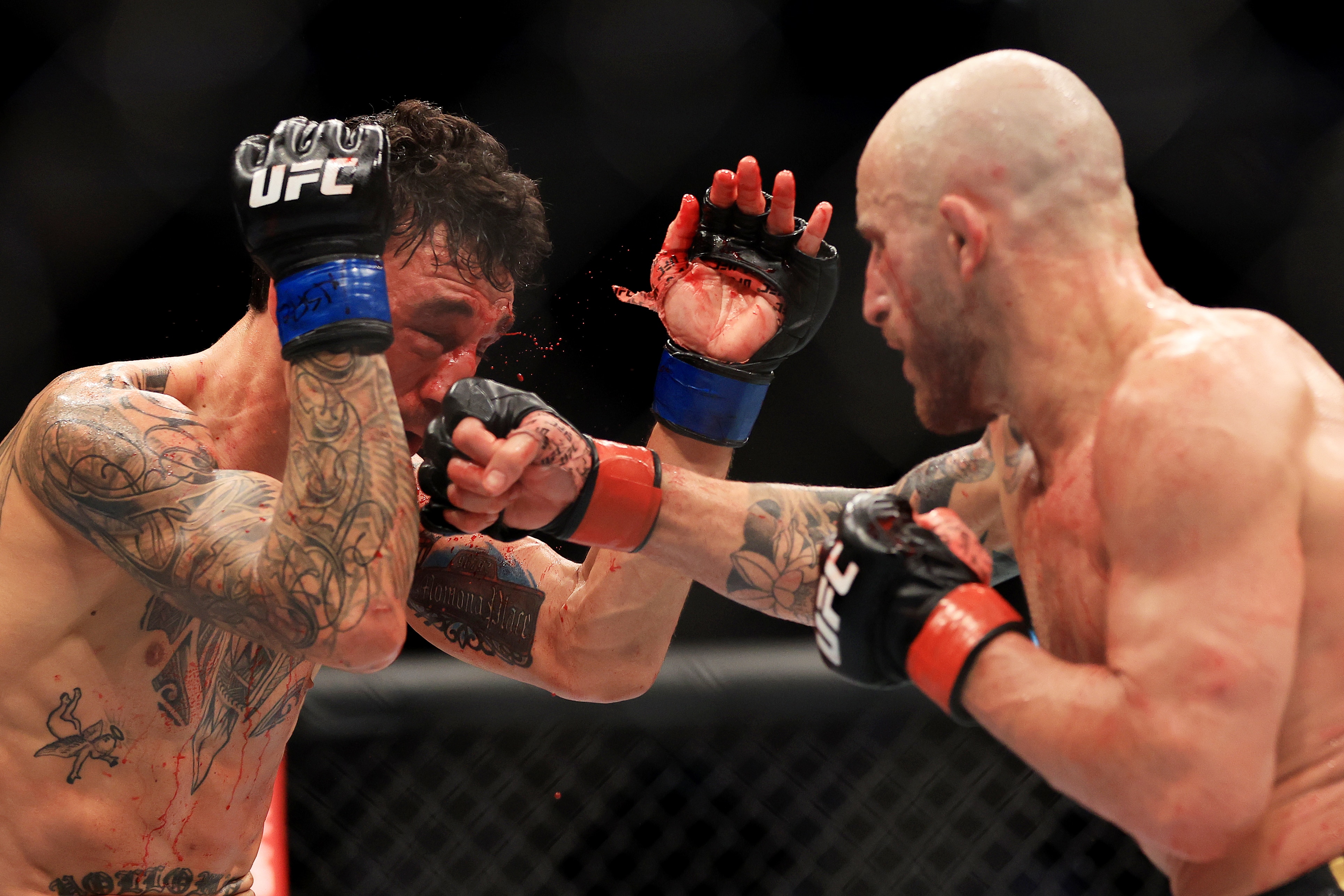 LAS VEGAS, NEVADA - JULY 02: Alexander Volkanovski (R) of Australia punches Max Holloway in their featherweight title bout during UFC 276 at T-Mobile Arena on July 02, 2022 in Las Vegas, Nevada. (Photo by Carmen Mandato/Getty Images)