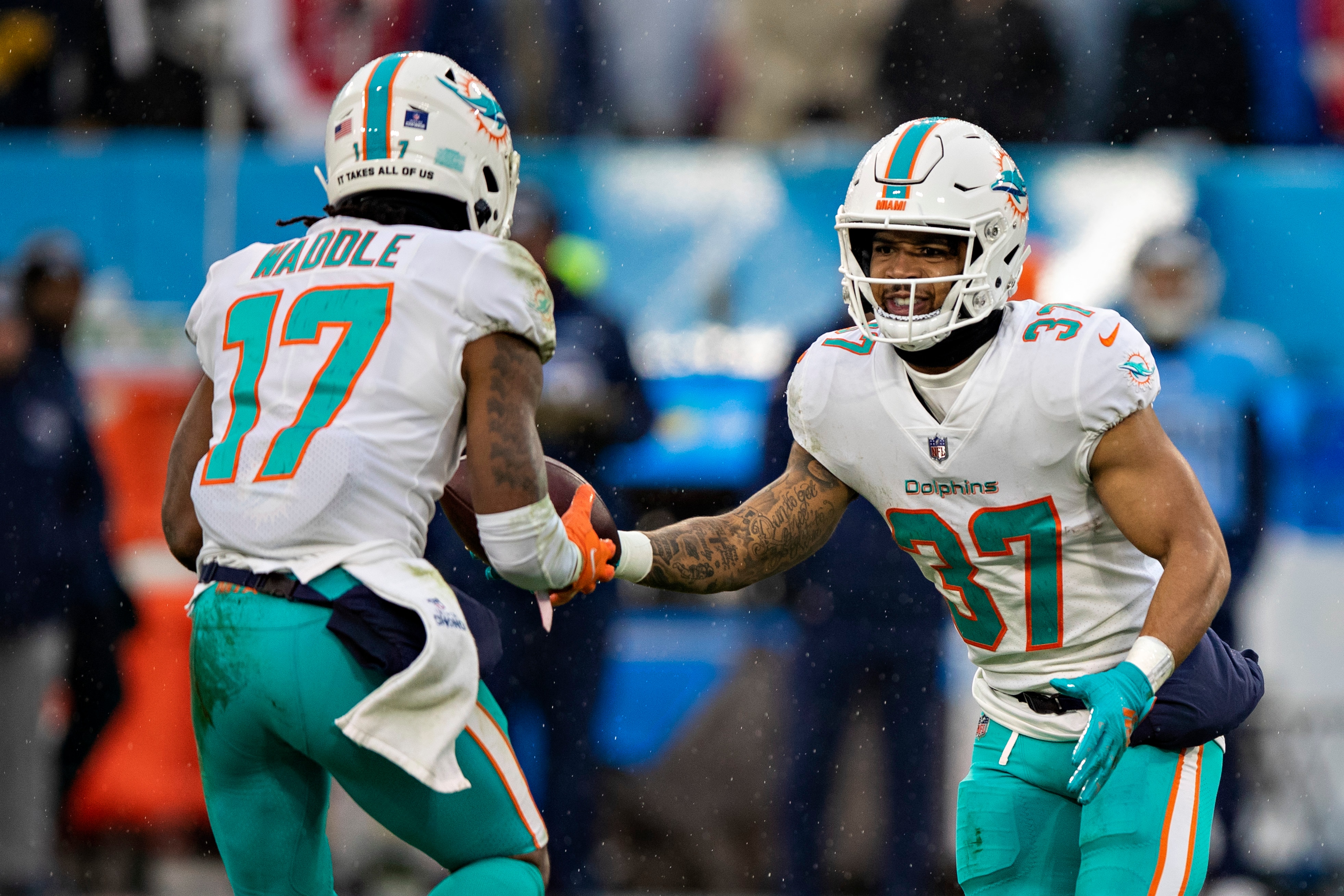 NASHVILLE, TENNESSEE - JANUARY 2:  Jaylen Waddle #17 takes a hand off from Myles Gaskin #37 of the Miami Dolphins during a game against the Tennessee Titans at Nissan Stadium on January 2, 2022 in Nashville, Tennessee.  The Titans defeated the Dolphins 34-3.  (Photo by Wesley Hitt/Getty Images)